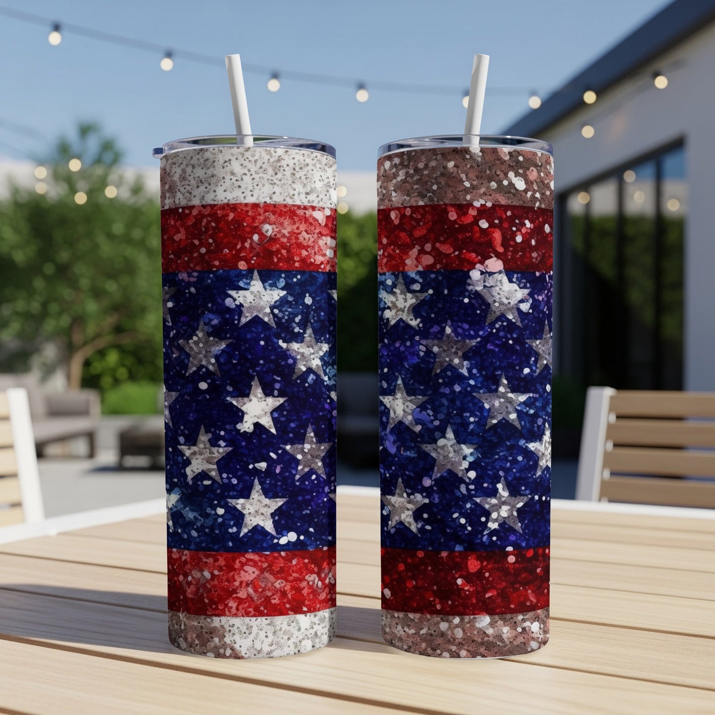 Two tall tumblers with a glittery American flag design stand on a wooden table.