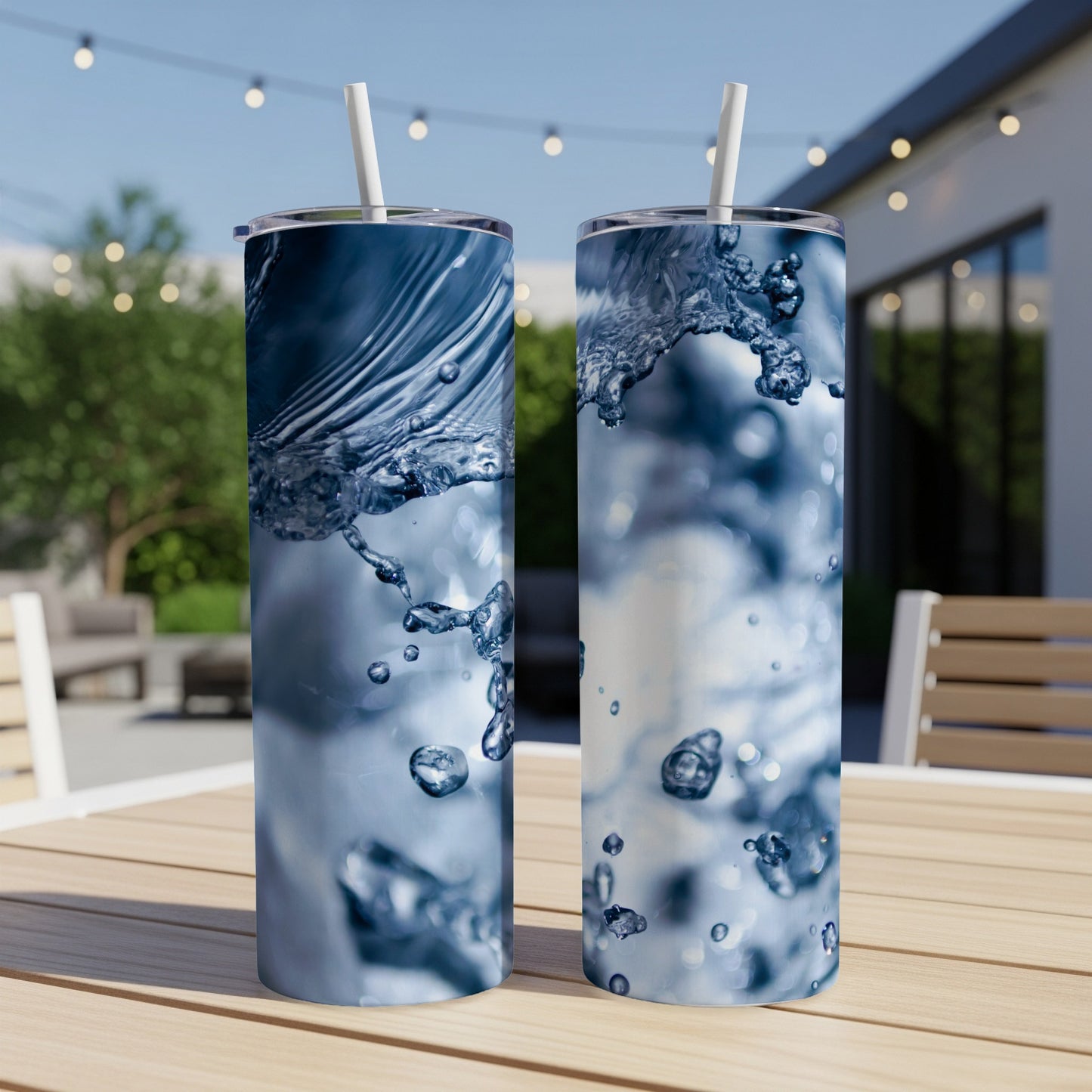 Two tumblers with abstract blue water splash graphics, sitting on a wooden table.