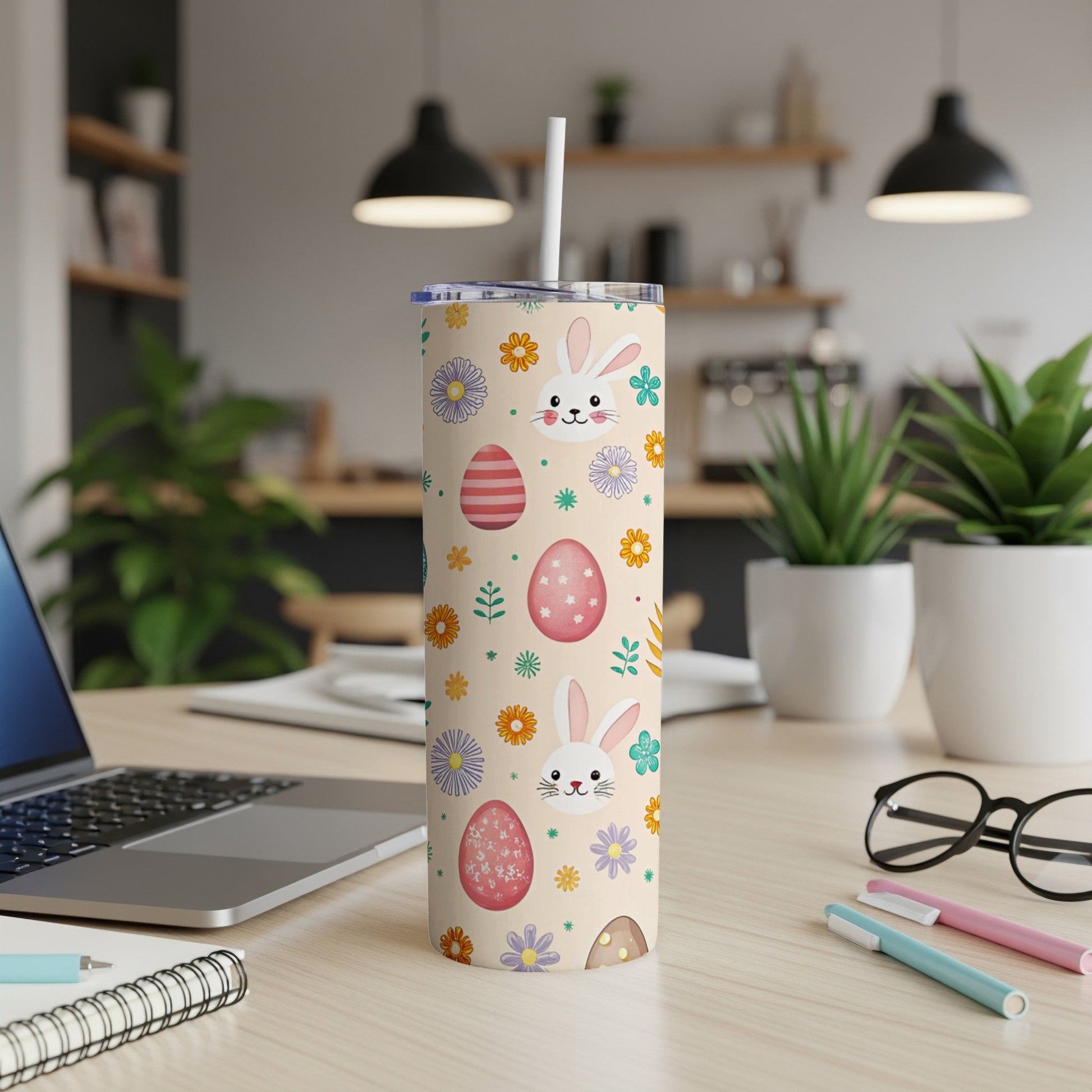 Tan tumbler with Easter bunnies, eggs, and flowers, with a straw.