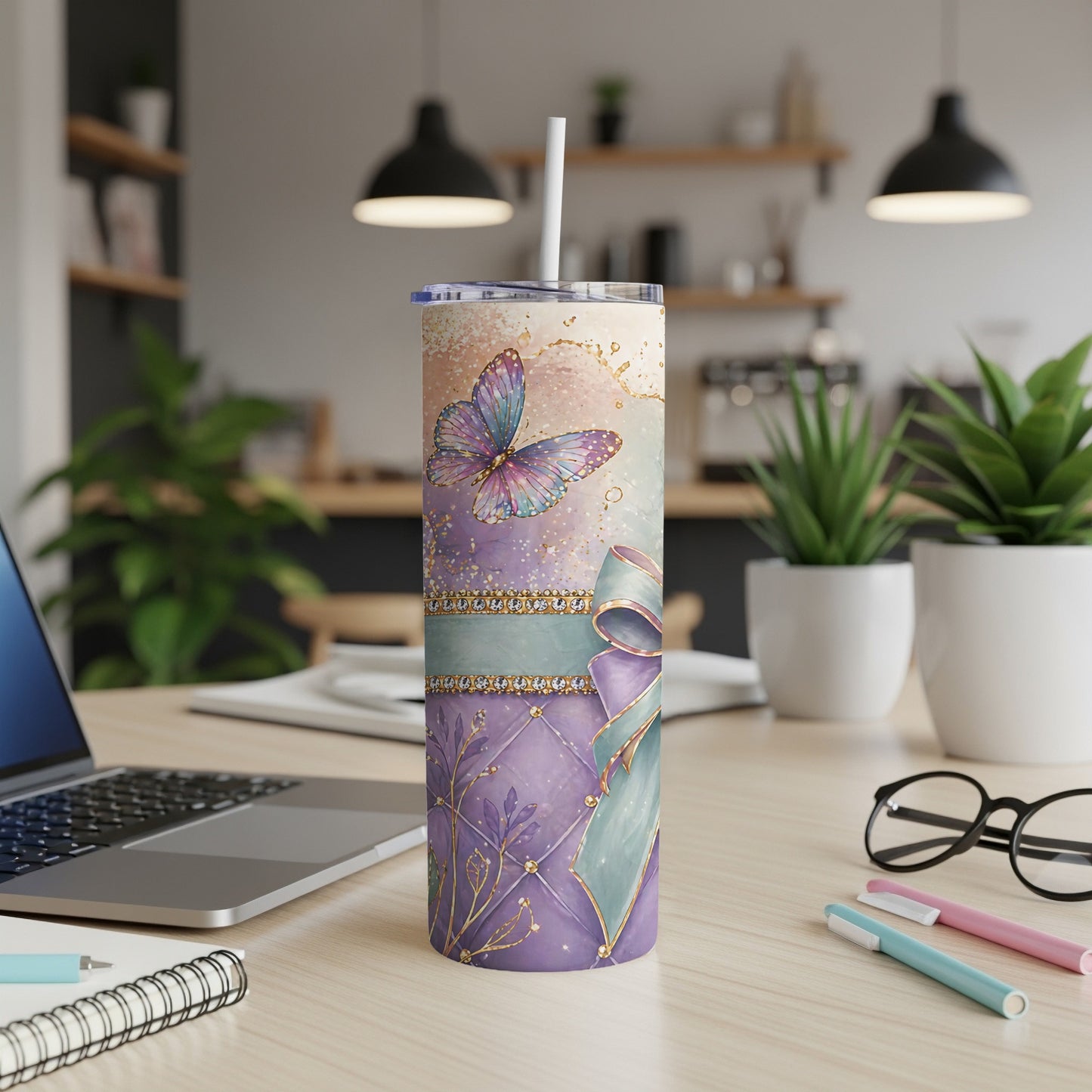 Purple tumbler with butterfly and gold accents, on desk with laptop.