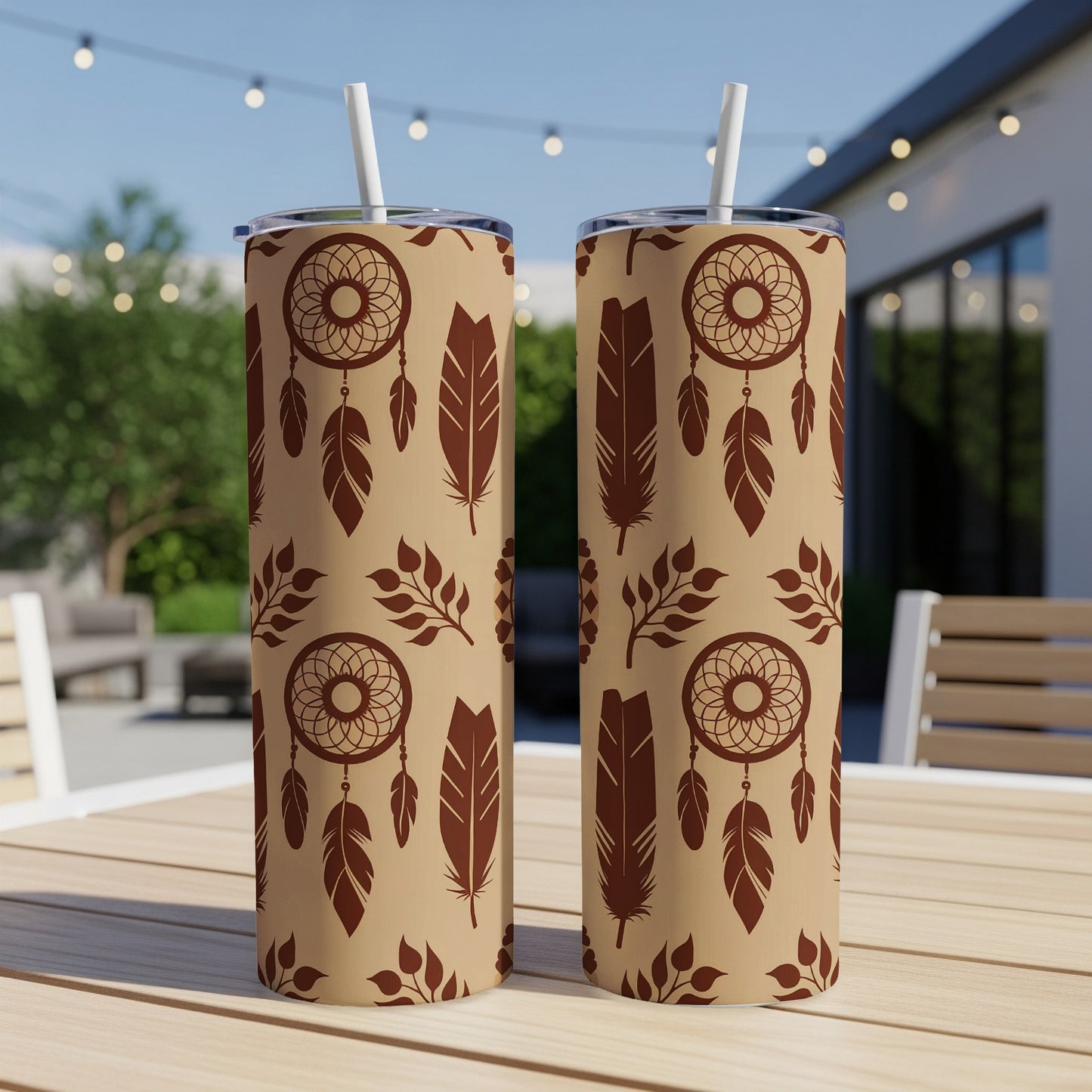 Two tan tumblers with dreamcatcher and feather pattern on a table.