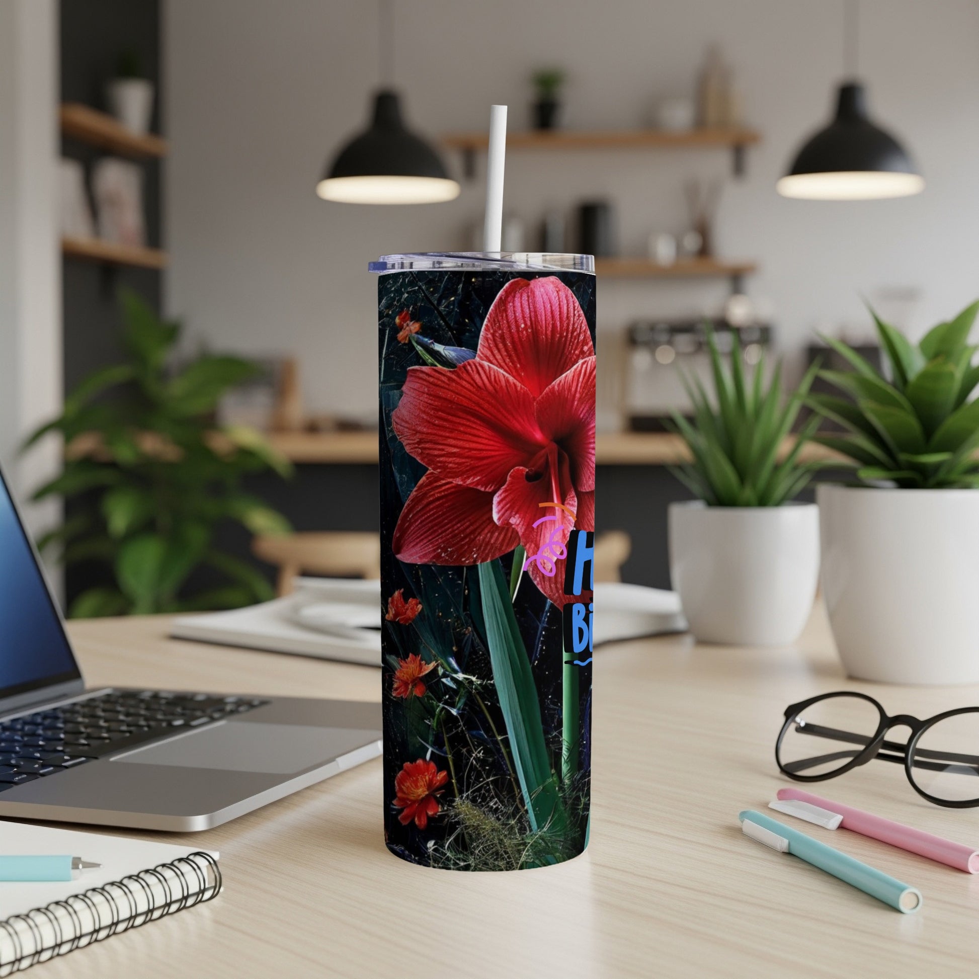 Red amaryllis flower design on a tall, skinny tumbler with a straw.