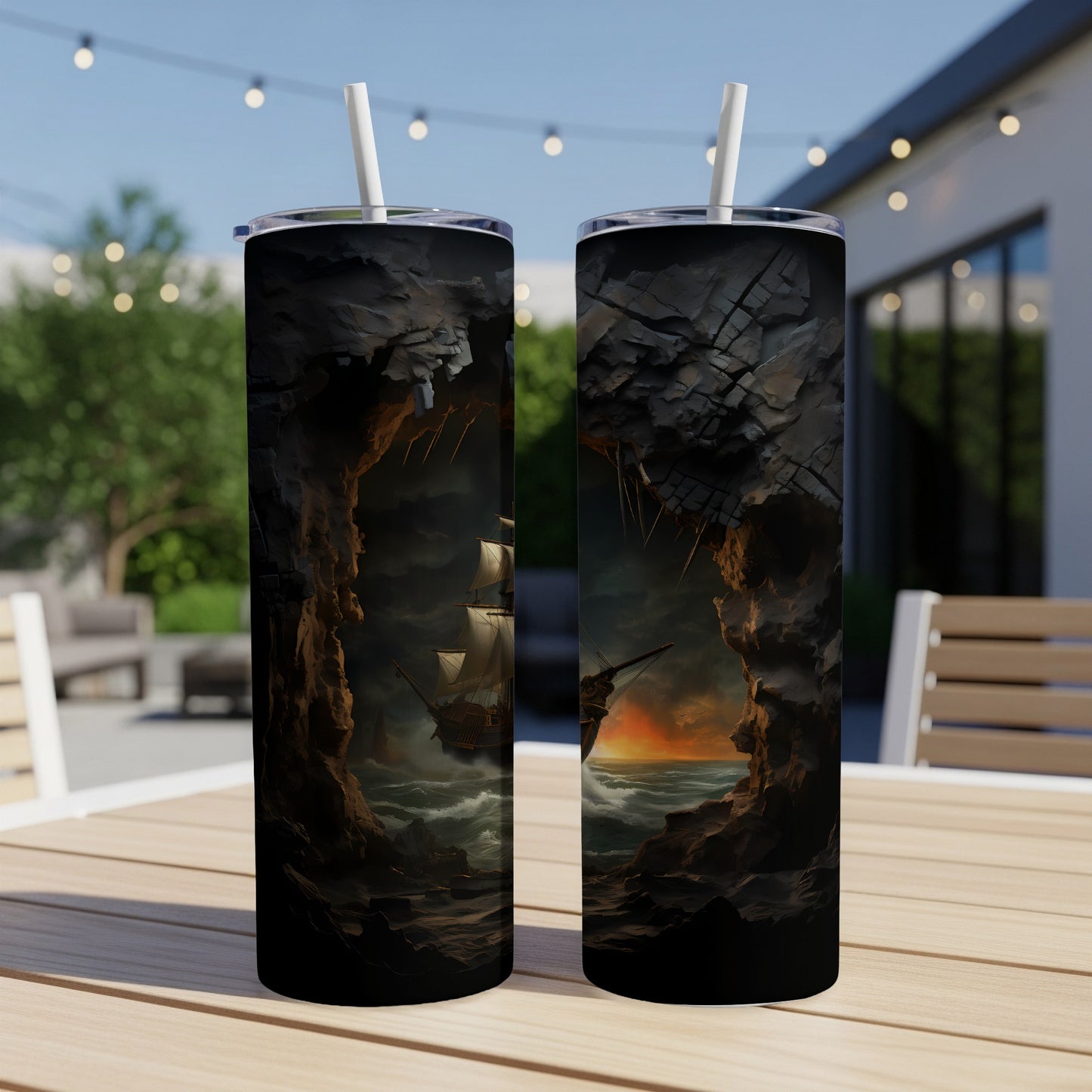 Two tumblers with a pirate ship emerging from a cave at sunset.