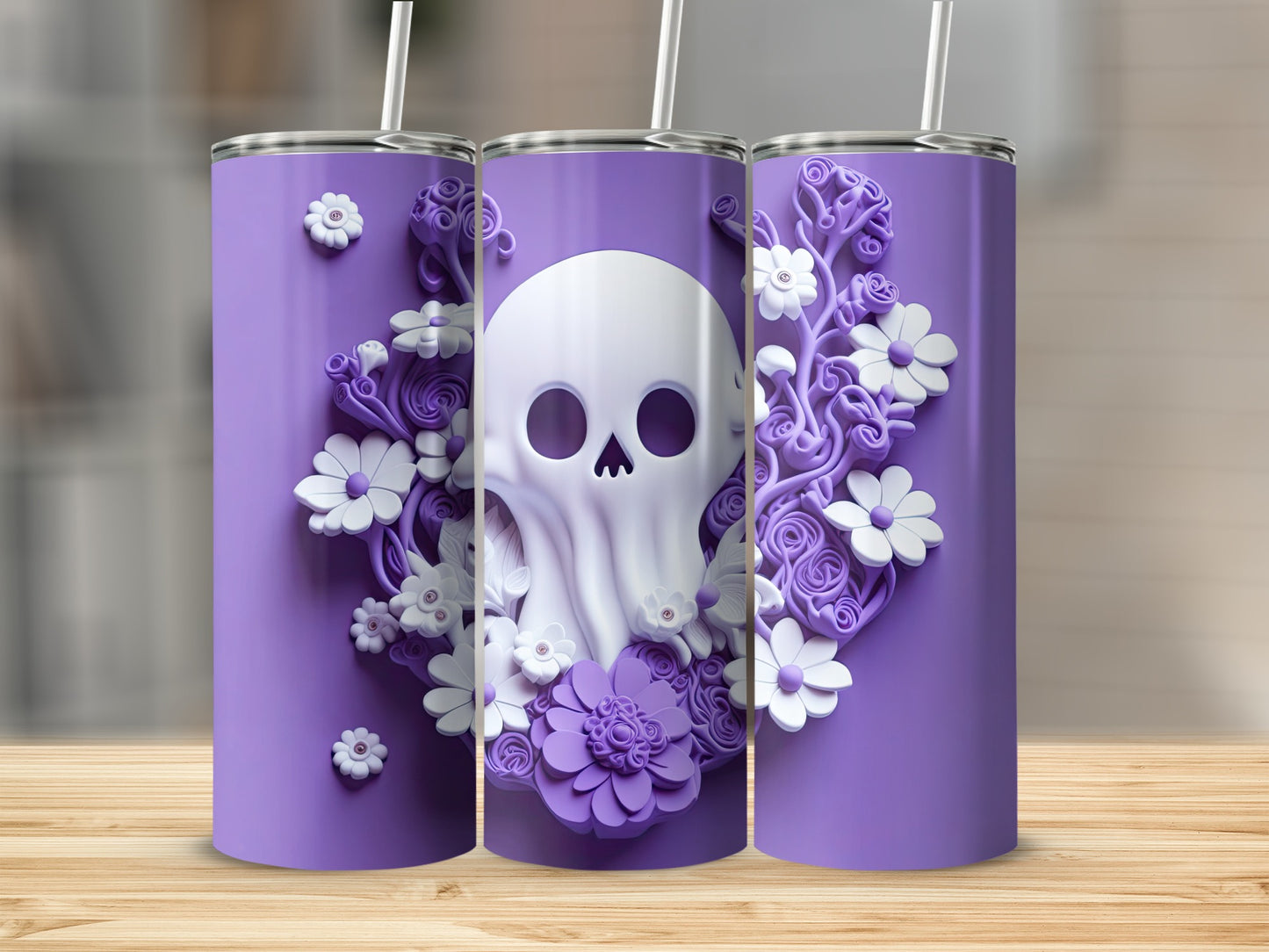 Three purple tumblers with white skull and floral designs and straws.