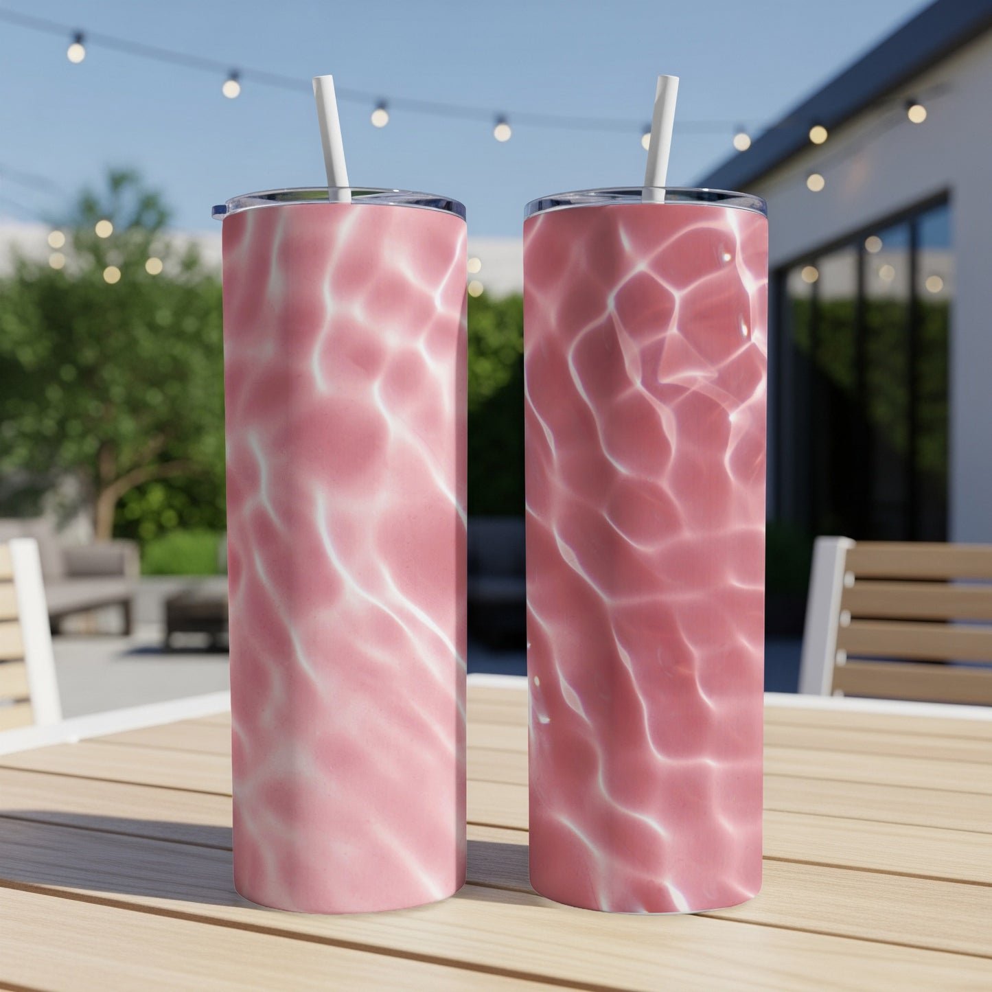 Two pink tumblers with water ripple pattern on a wooden table.