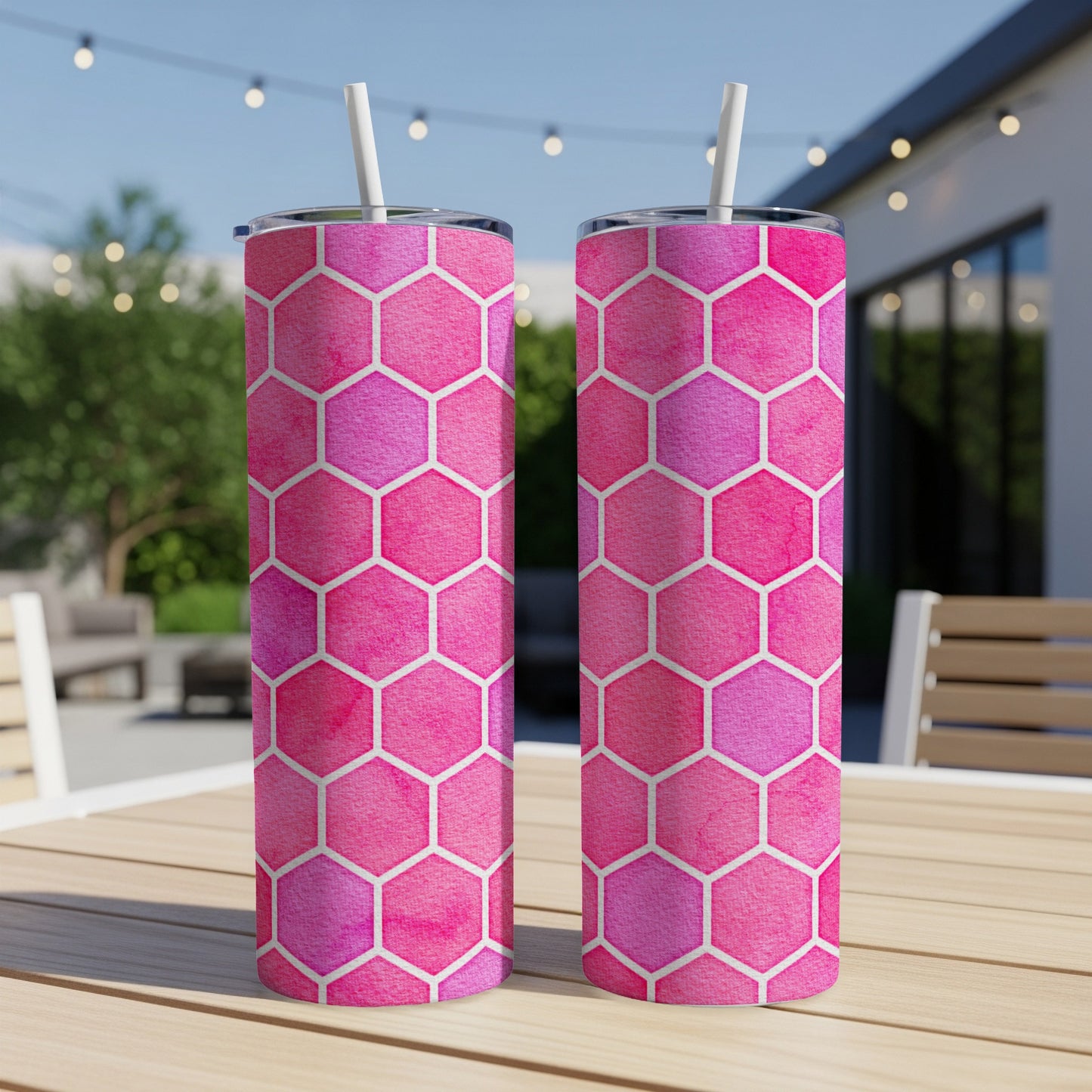 Two pink and purple watercolor hexagon tumblers with white straws on a table.