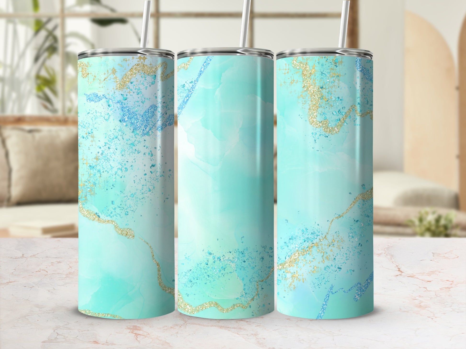 Three teal and gold marble pattern tumblers with straws.