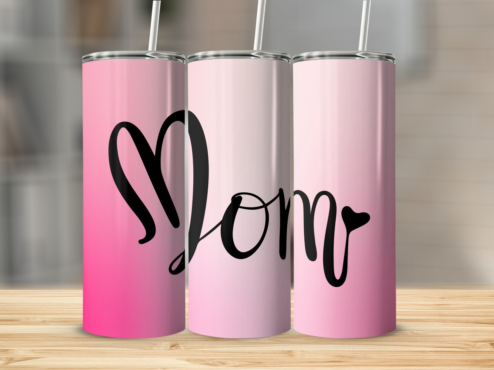 Three tumblers with "Mom" in a black script on a pink gradient background.