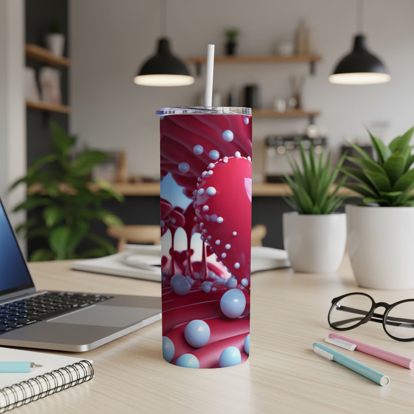 Red and blue abstract design on a white tumbler with straw.