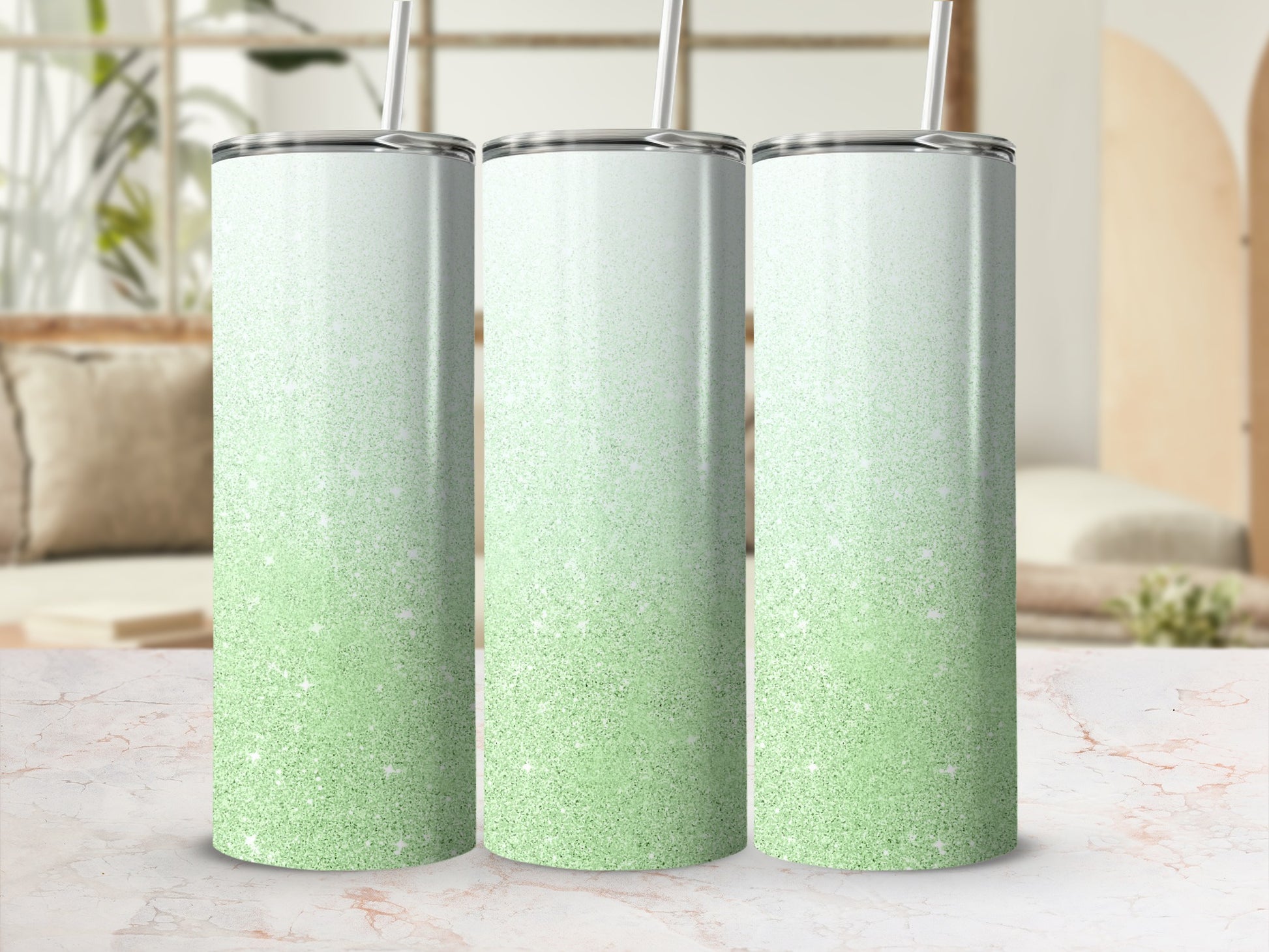 Three green glitter gradient tumblers with straws, displayed on a marble surface.