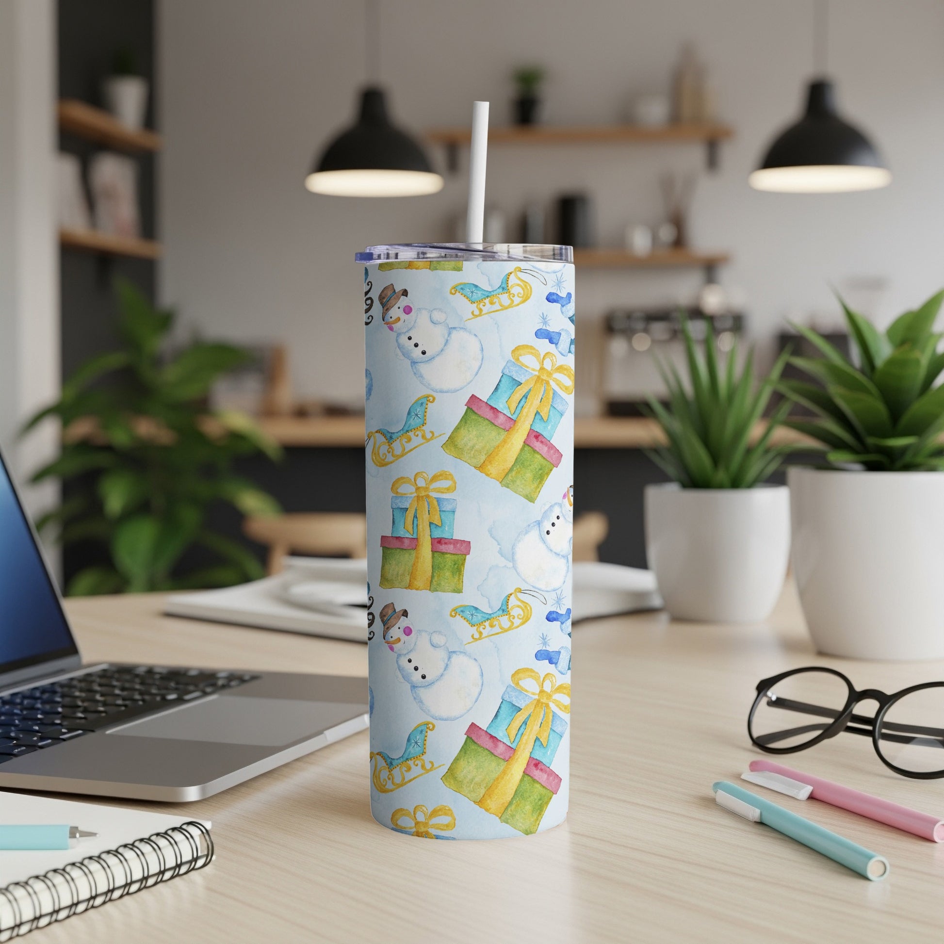 Blue tumbler with snowman and gift designs, straw inserted.