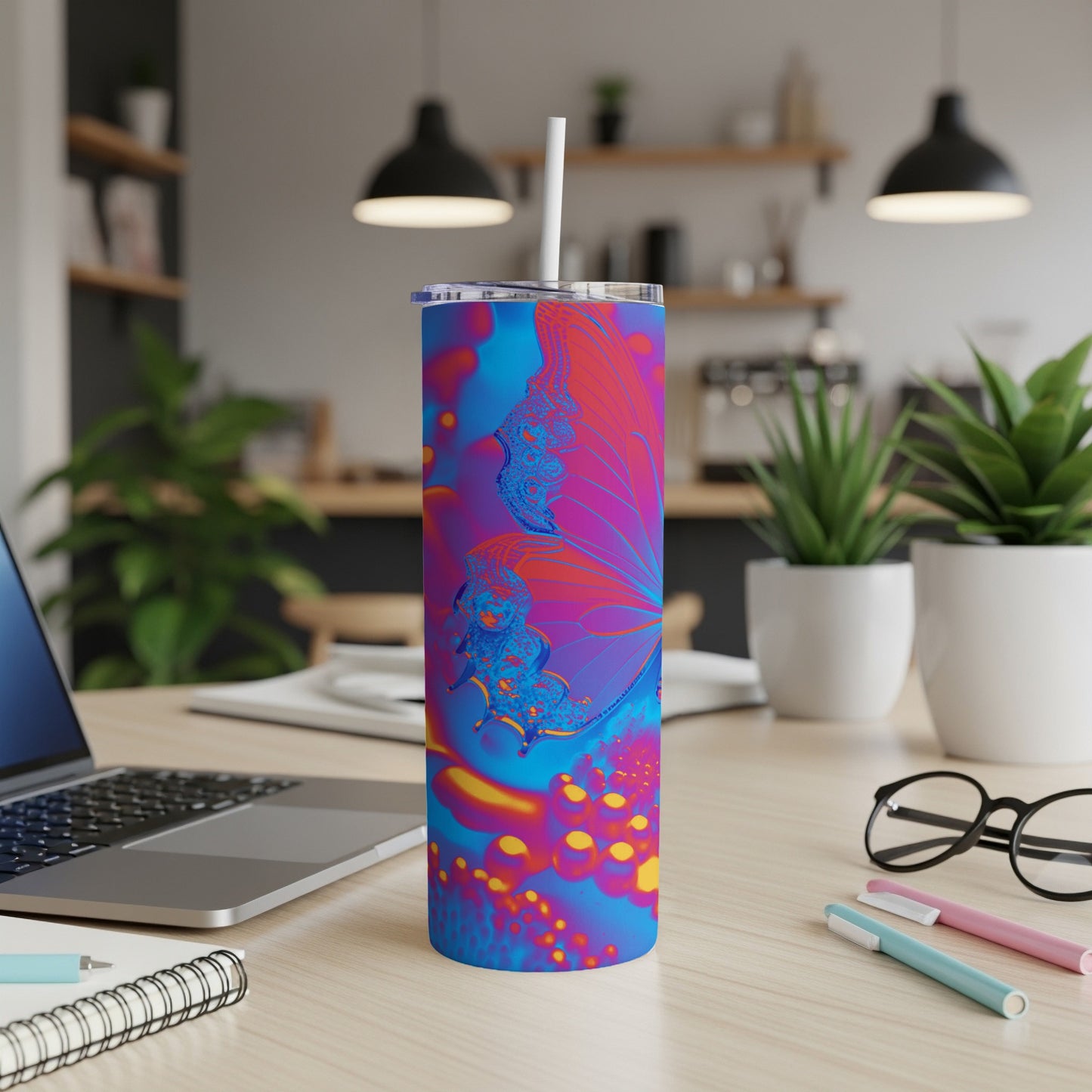 Tumbler with colorful butterfly design on desk.