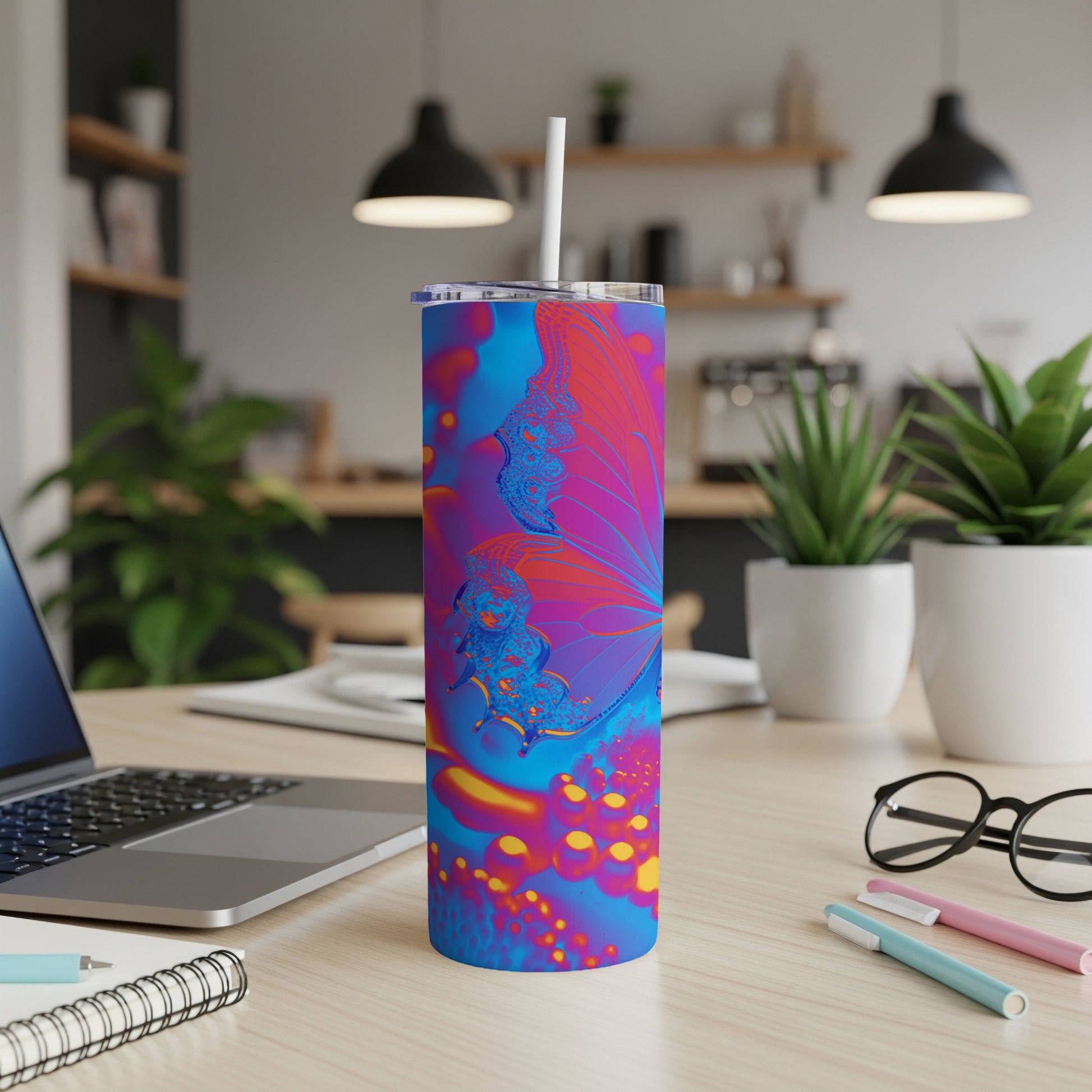 Tumbler with colorful butterfly design on desk.