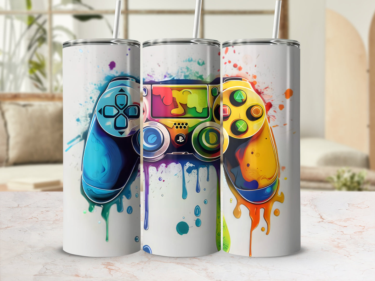 Three colorful video game controllers with paint splatters on white tumblers.