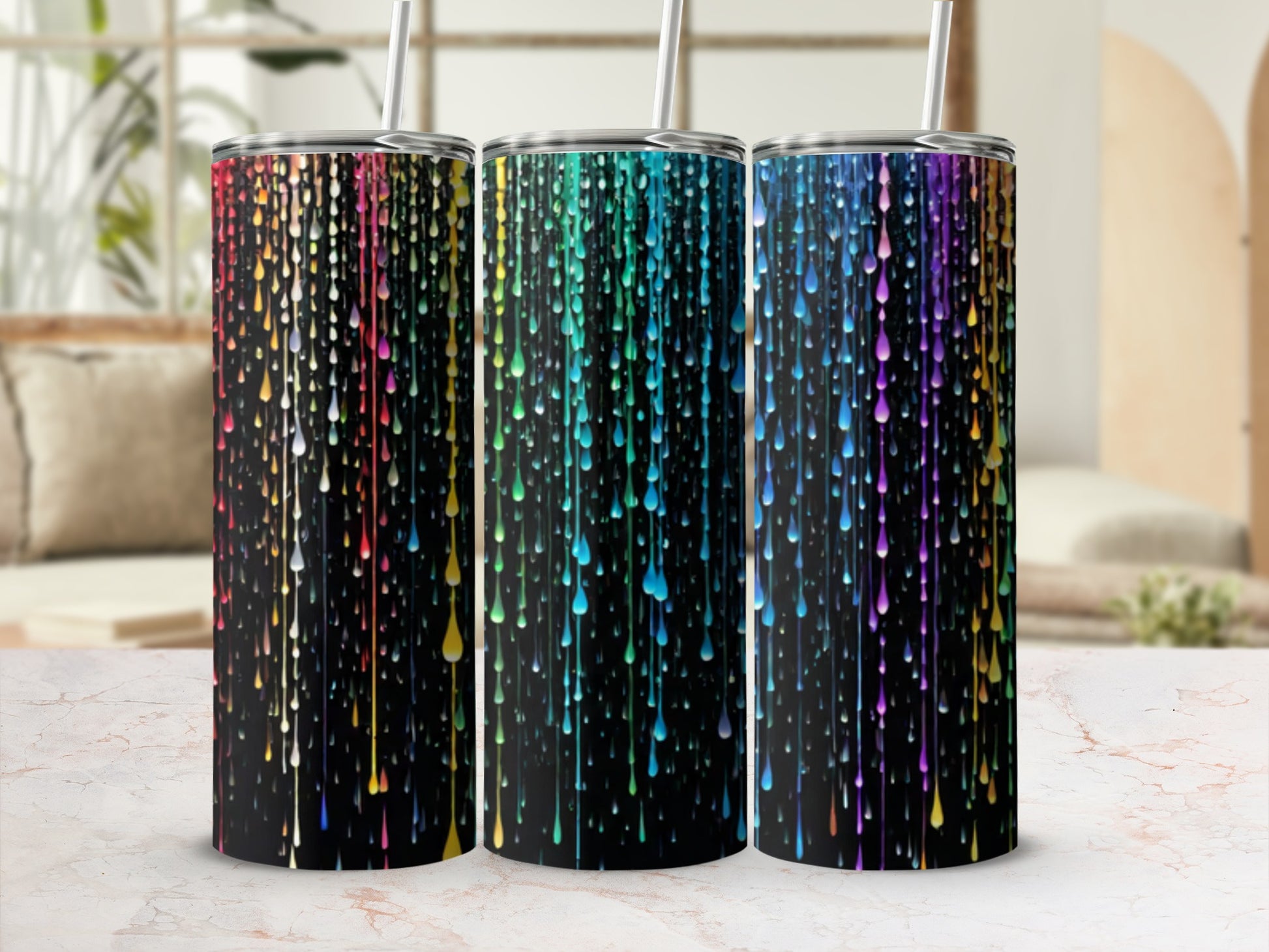 Three tumblers with colorful dripping paint design on black background.