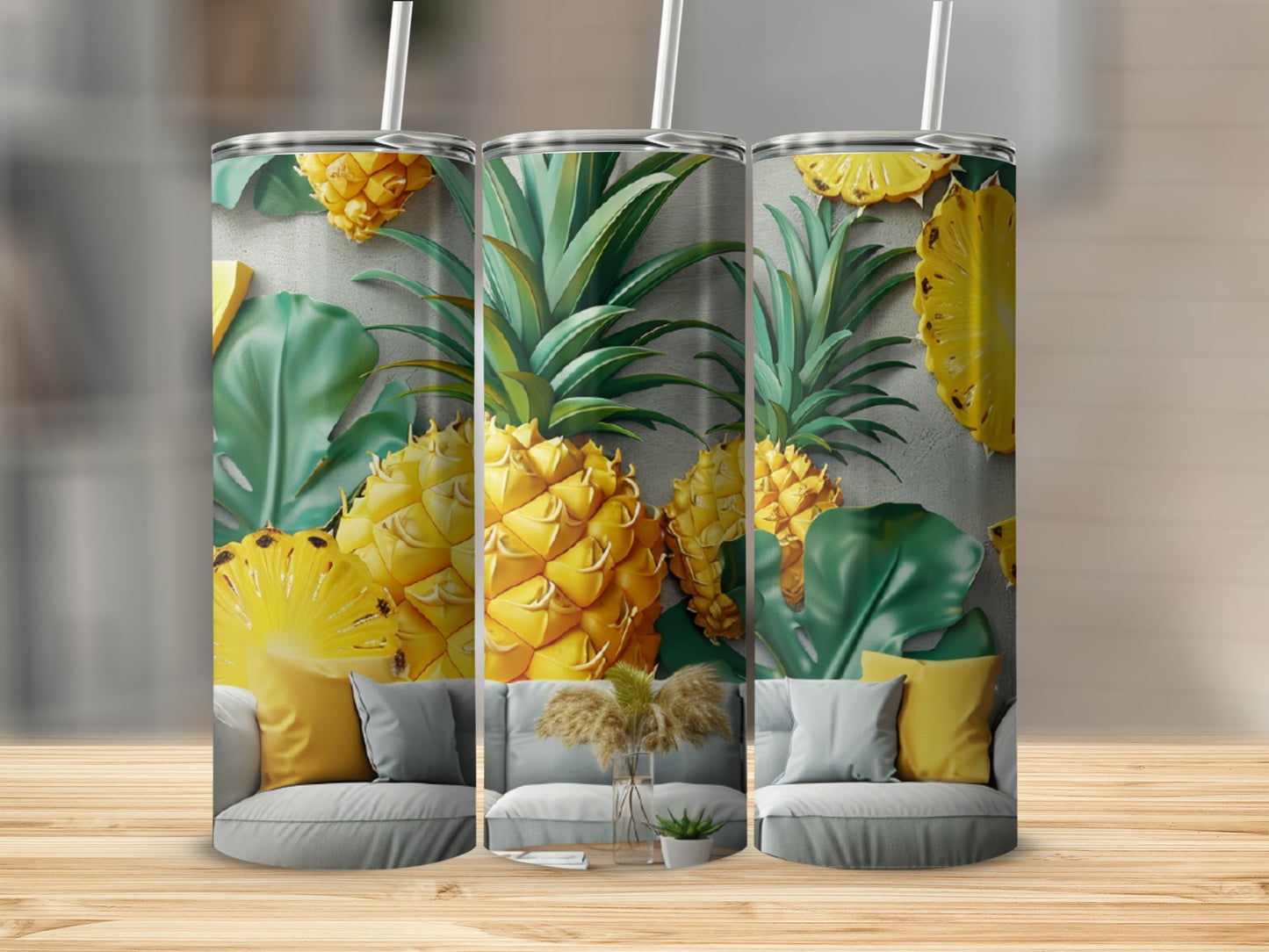 Three tumblers with pineapple and leaf design on couch.