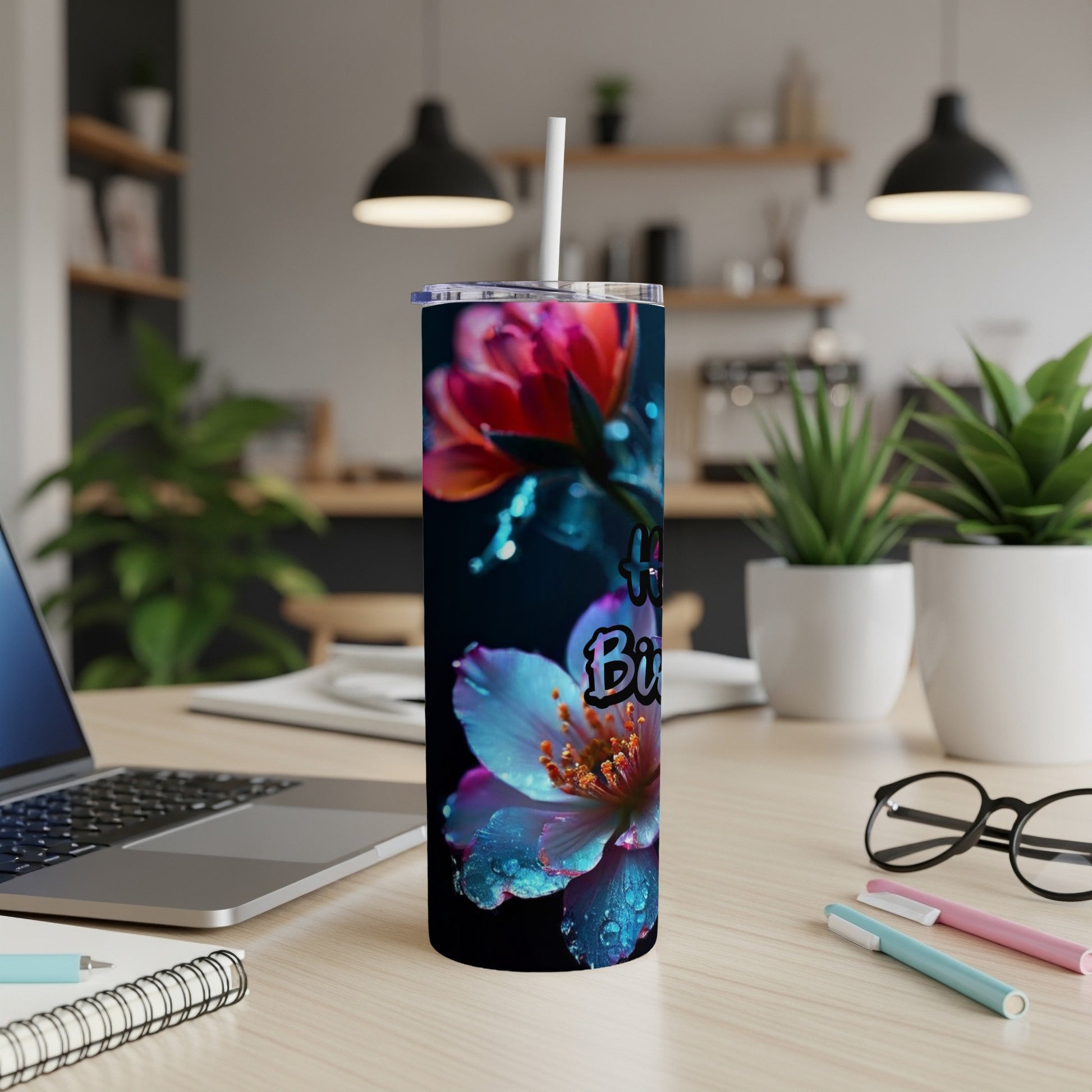 Floral tumbler with "Happy Birthday" text, resting on a desk.