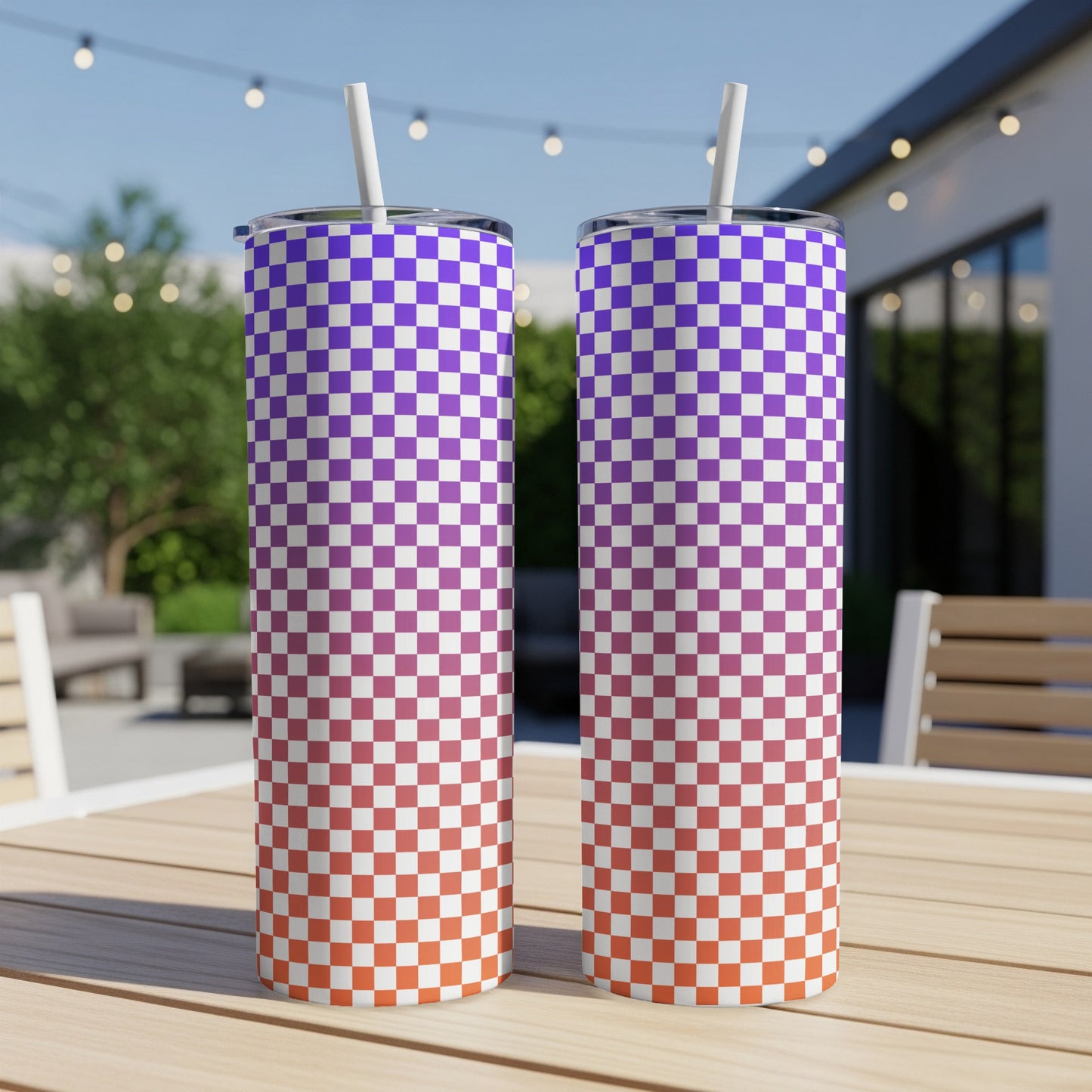 Two tumblers with a purple and orange checkered gradient pattern, outdoors.
