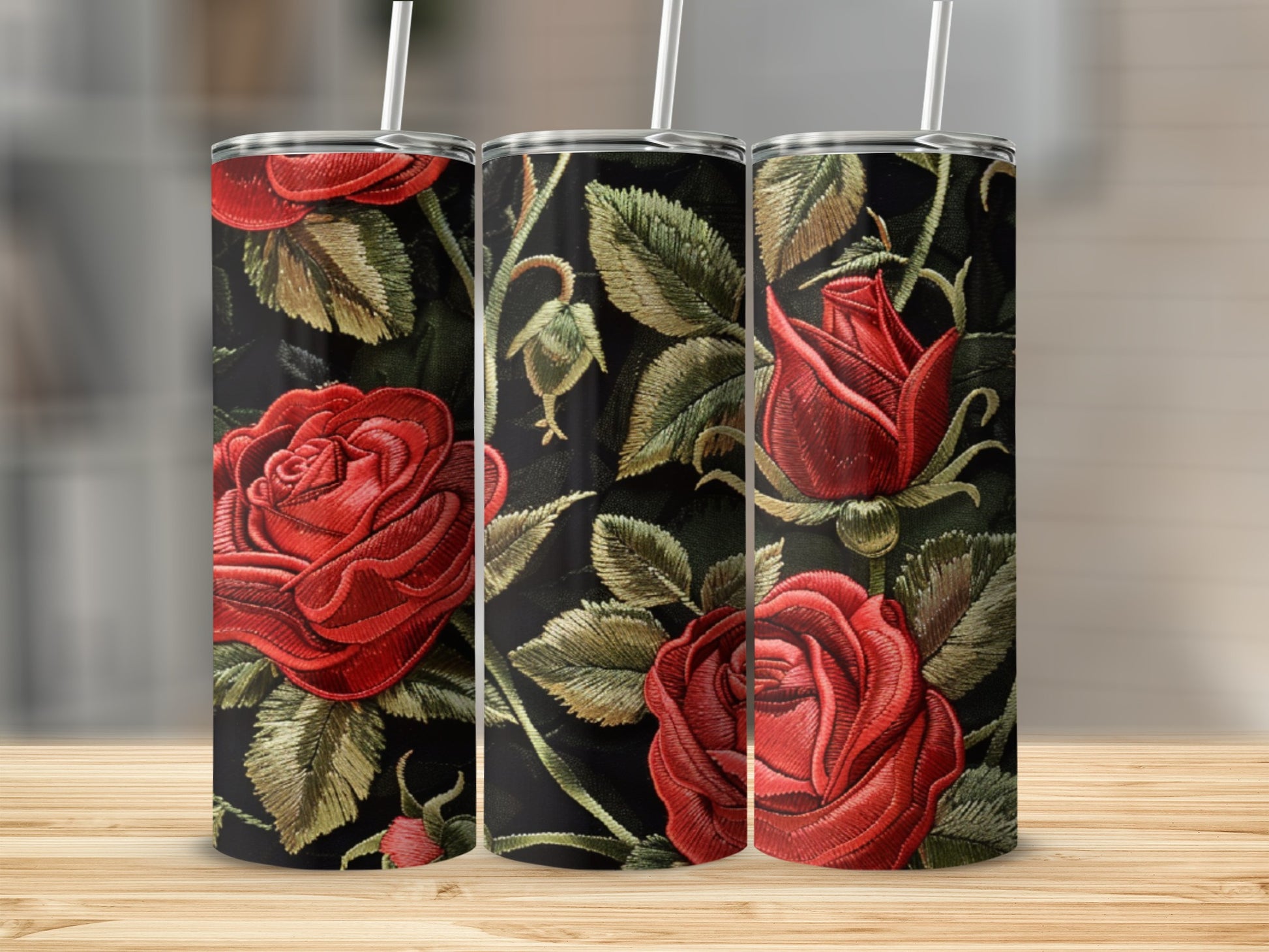 Three tumblers with red rose embroidery pattern on black background.