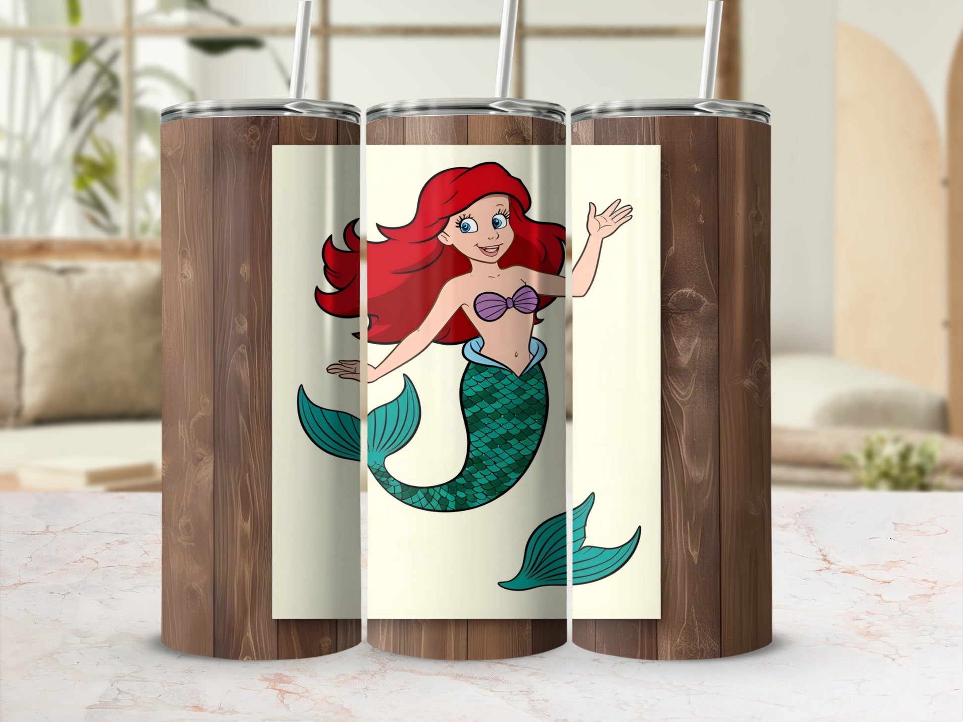 Ariel the mermaid with red hair and green tail waves on a tumbler.