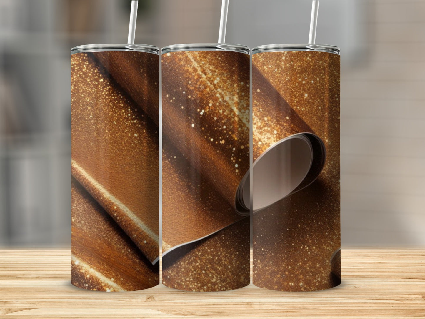 Three tumblers with a sparkling golden glitter design on a wooden surface.