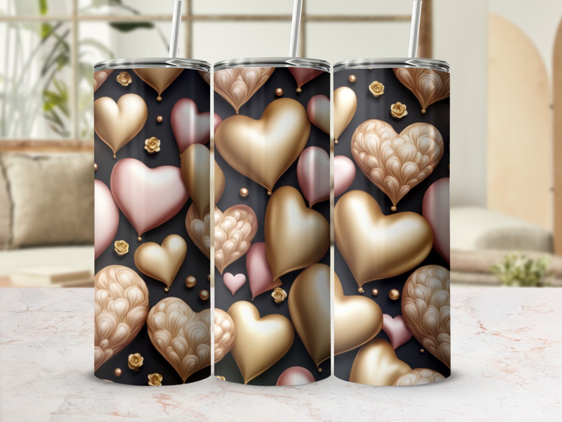 Three tumblers with a gold and pink heart pattern on a marble surface.