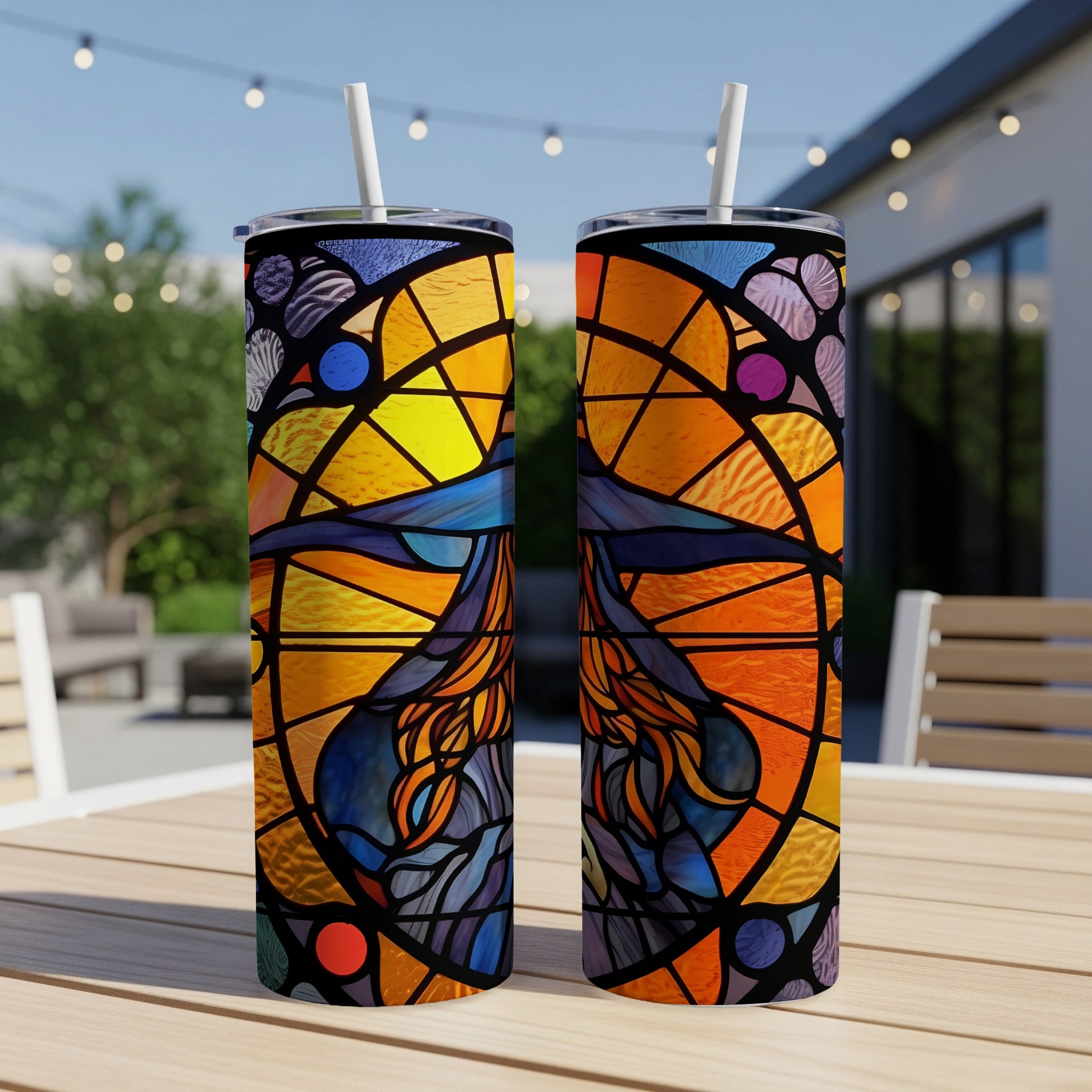 Two stained glass tumblers featuring a witch and moon design on a patio table.