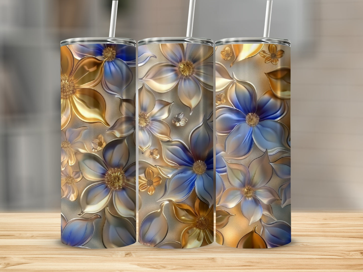Three tall tumblers with embossed golden and blue floral designs.
