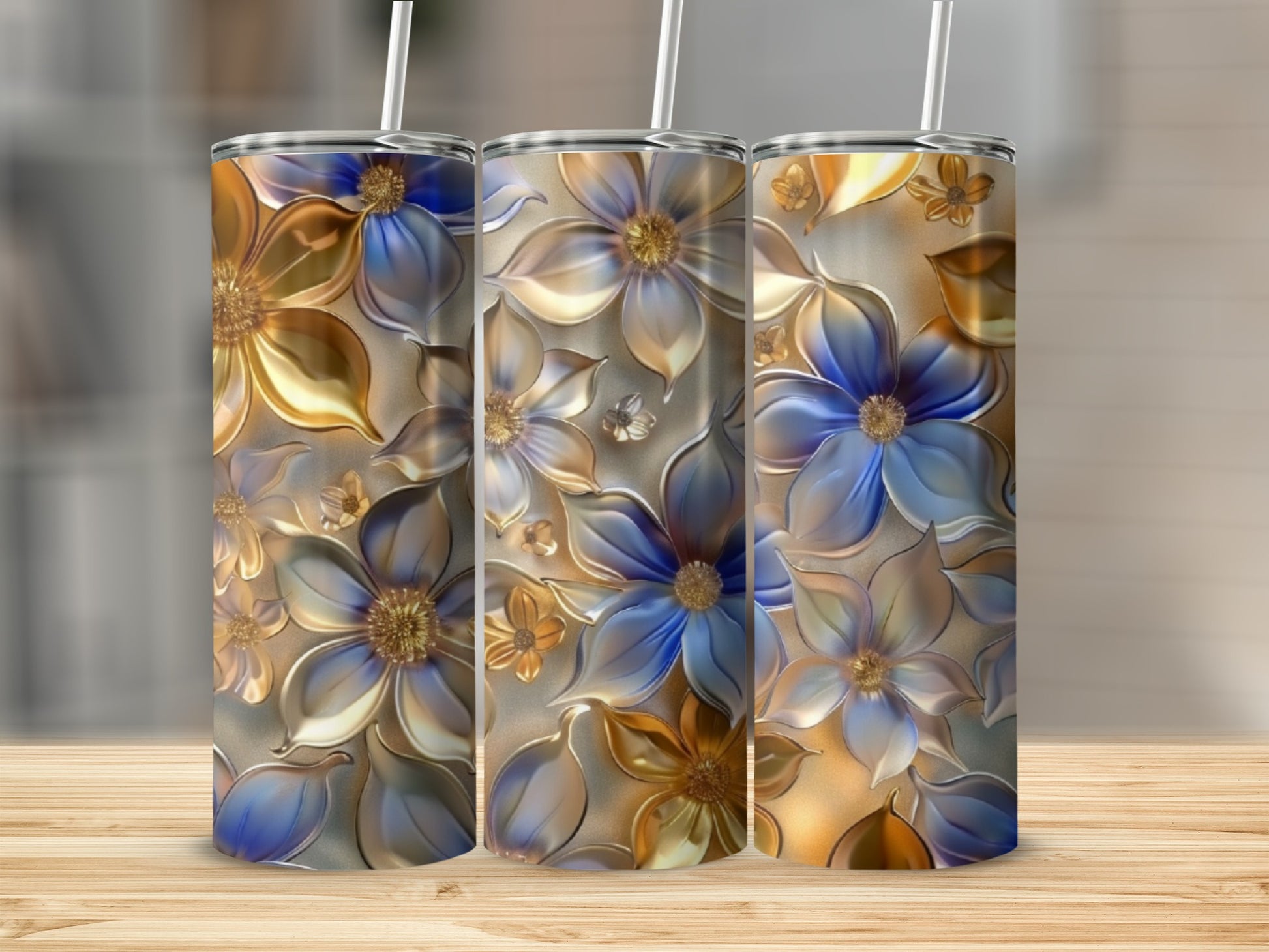 Three tall tumblers with embossed golden and blue floral designs.