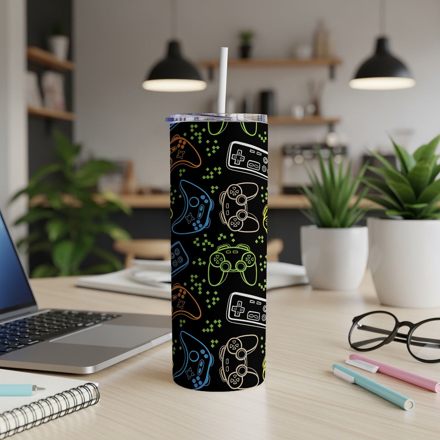 Skinny tumbler with neon video game controllers on a black background.