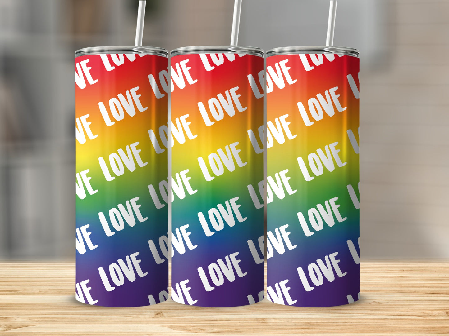 Three tumblers with rainbow stripes and "LOVE" repeated across them.