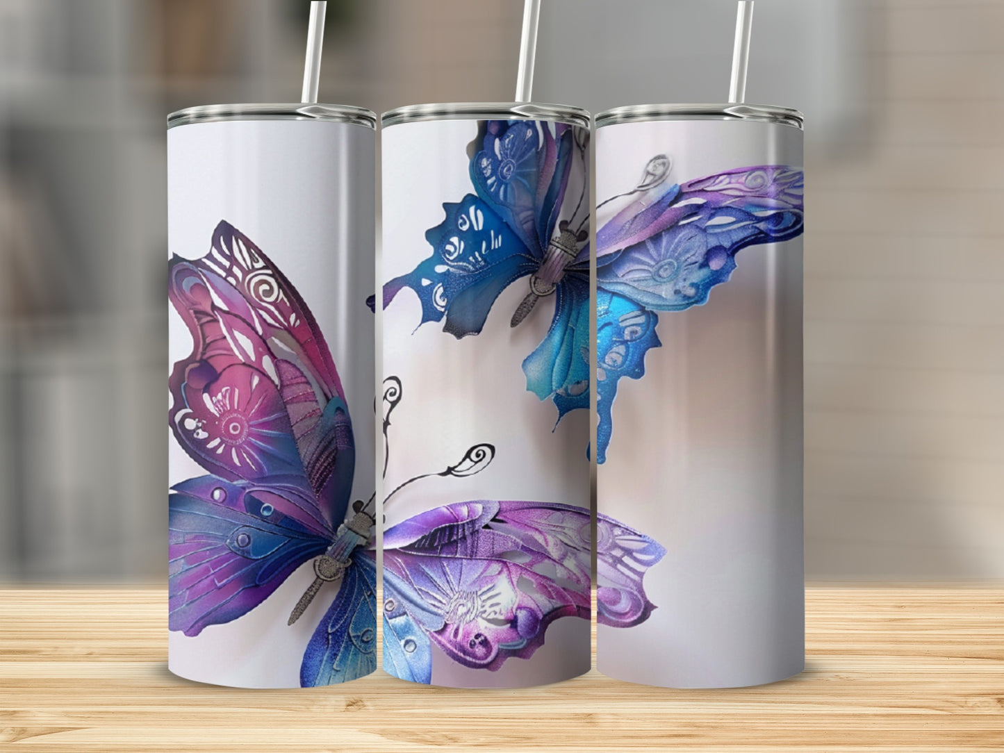 Three tumblers featuring watercolor butterfly designs in purple and blue.