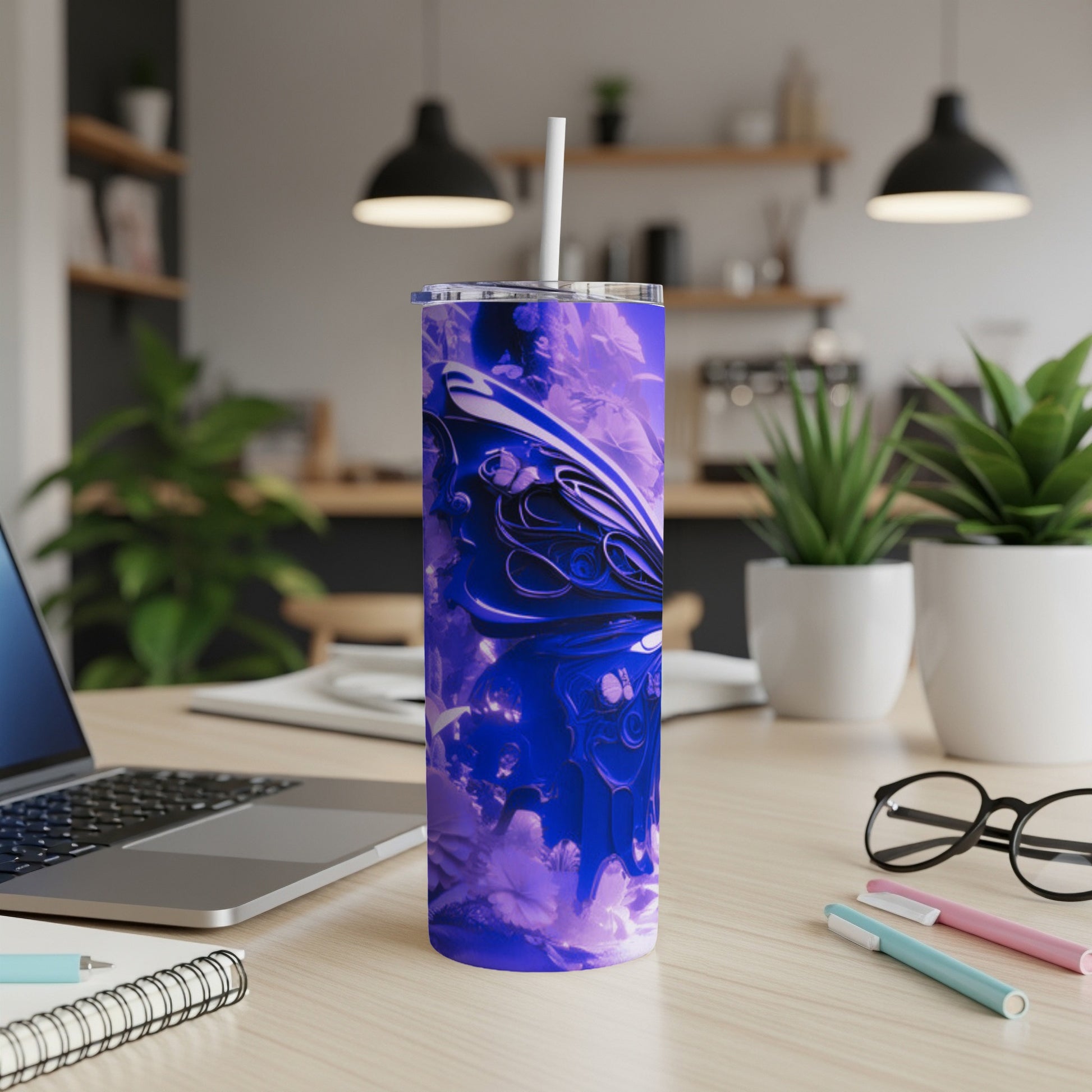 Blue abstract design tumbler on desk next to laptop and pens.
