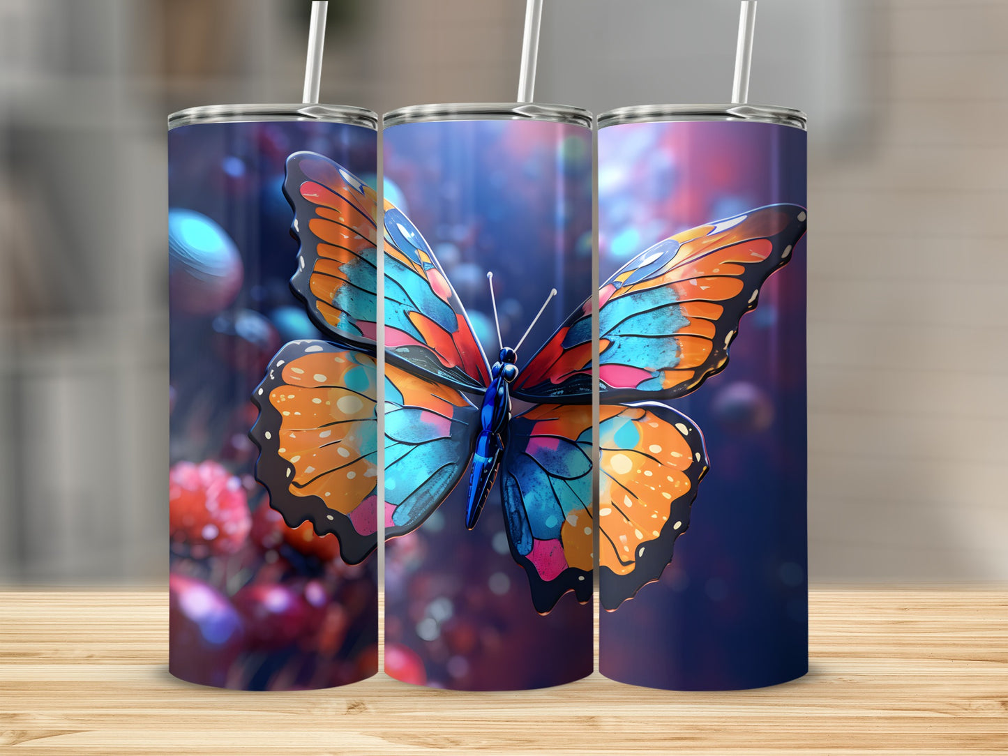 Three tumblers with a vibrant butterfly design on a wooden surface.