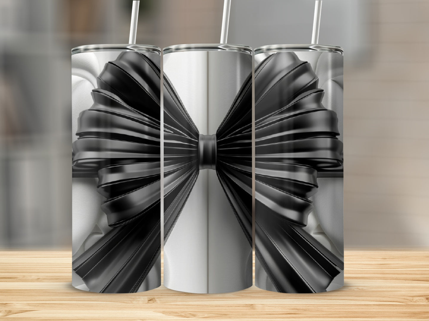 Three tumblers with black ribbon bows, presented on a wooden surface.