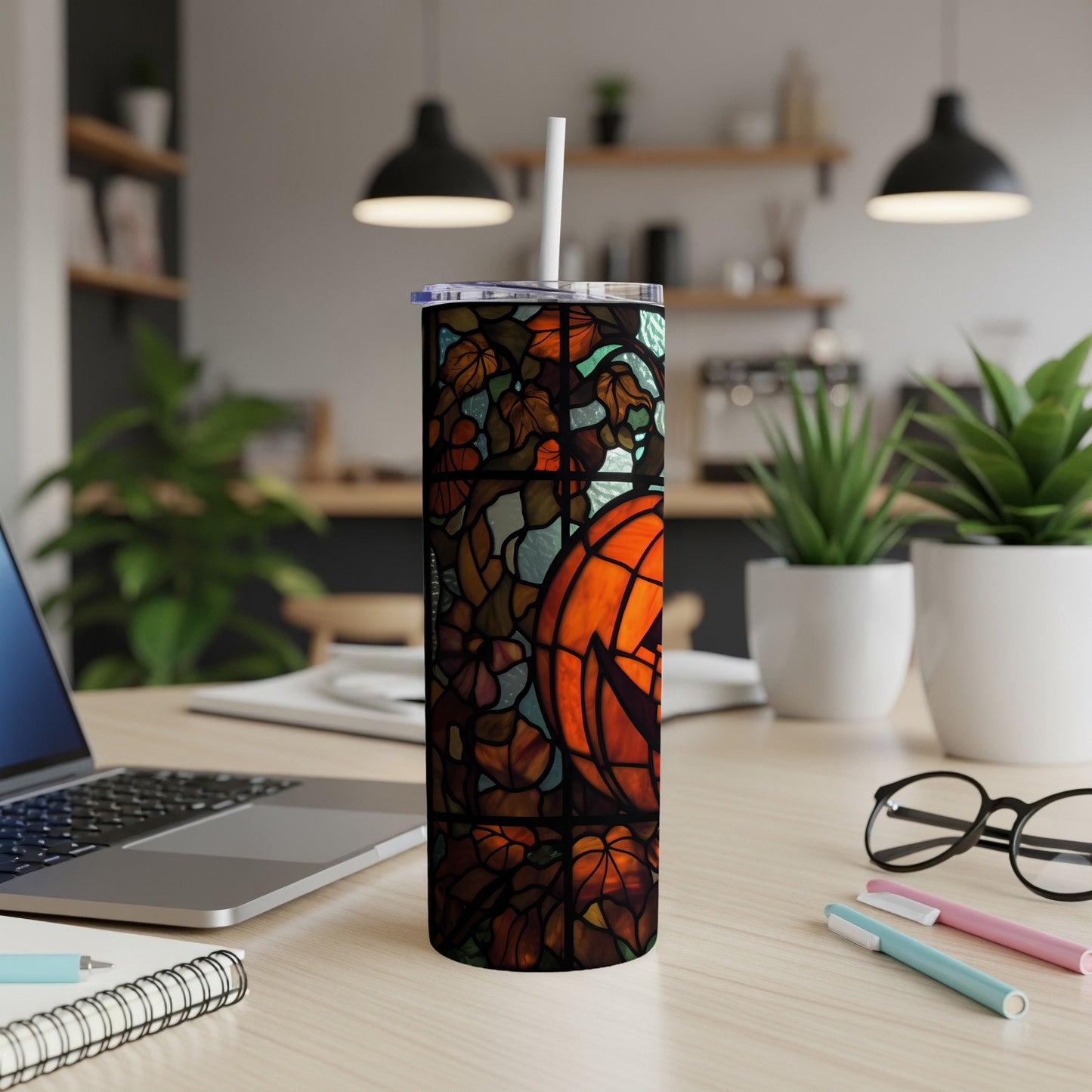 Stained glass pumpkin design on a tumbler with a white straw.
