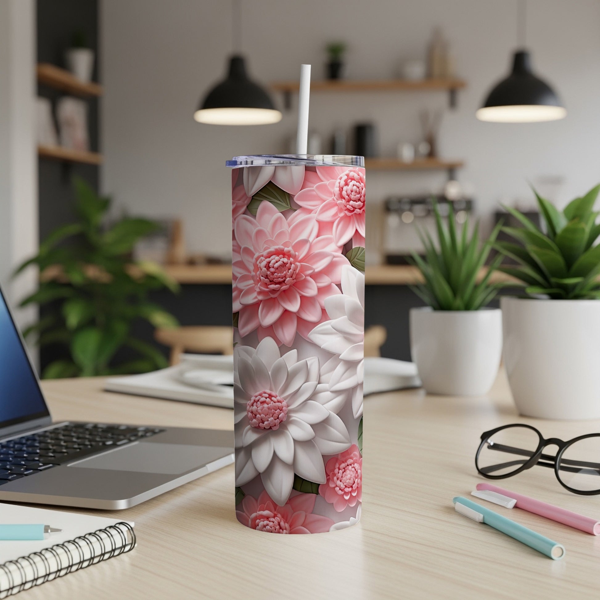 Pink and white dahlia flowers pattern on a white tumbler with a straw.