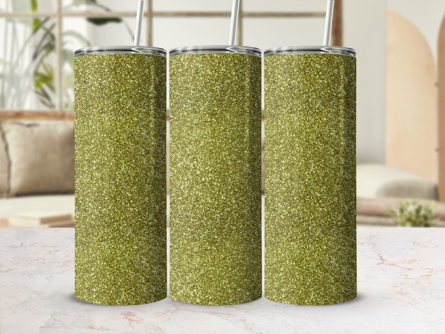 Three glittery green tumblers with straws stand on a marble surface.