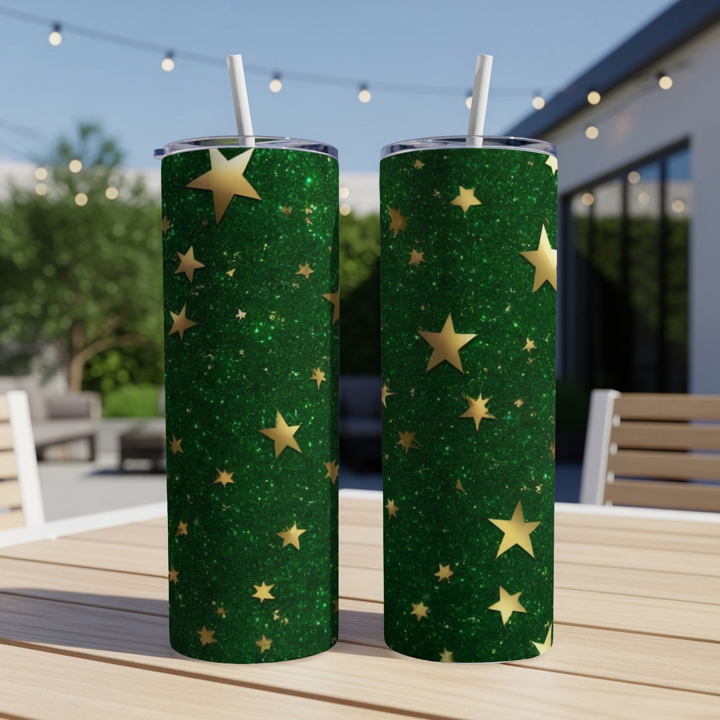 Two tall, green glitter tumblers with gold stars, outdoors on a table.