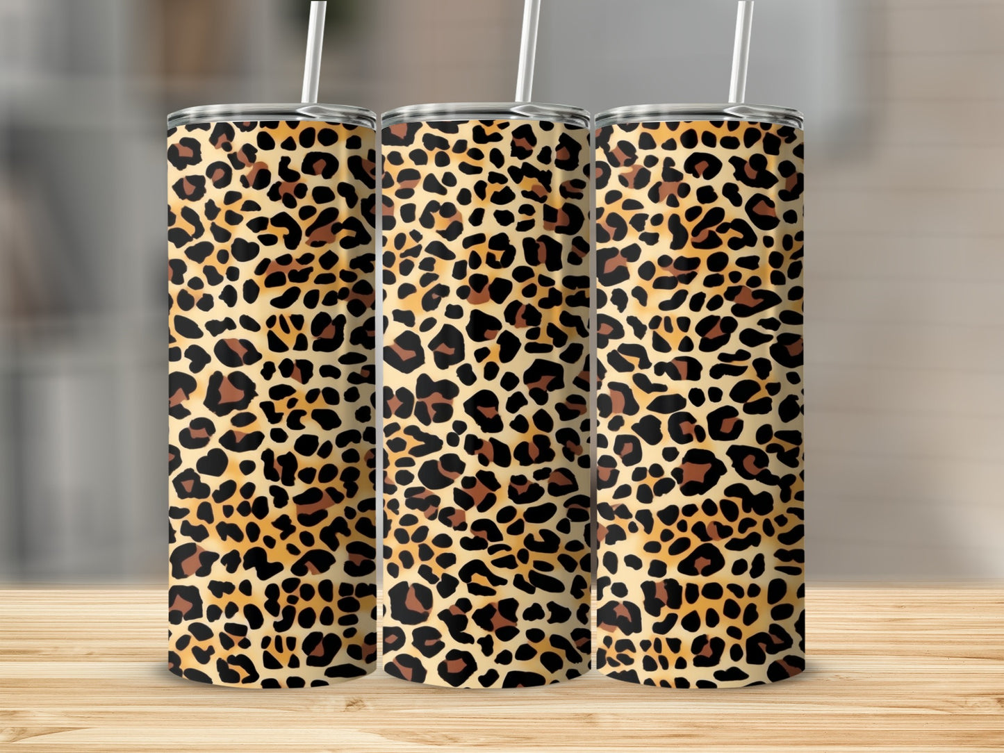 Three tumblers with leopard print patterns stand on a wooden surface.