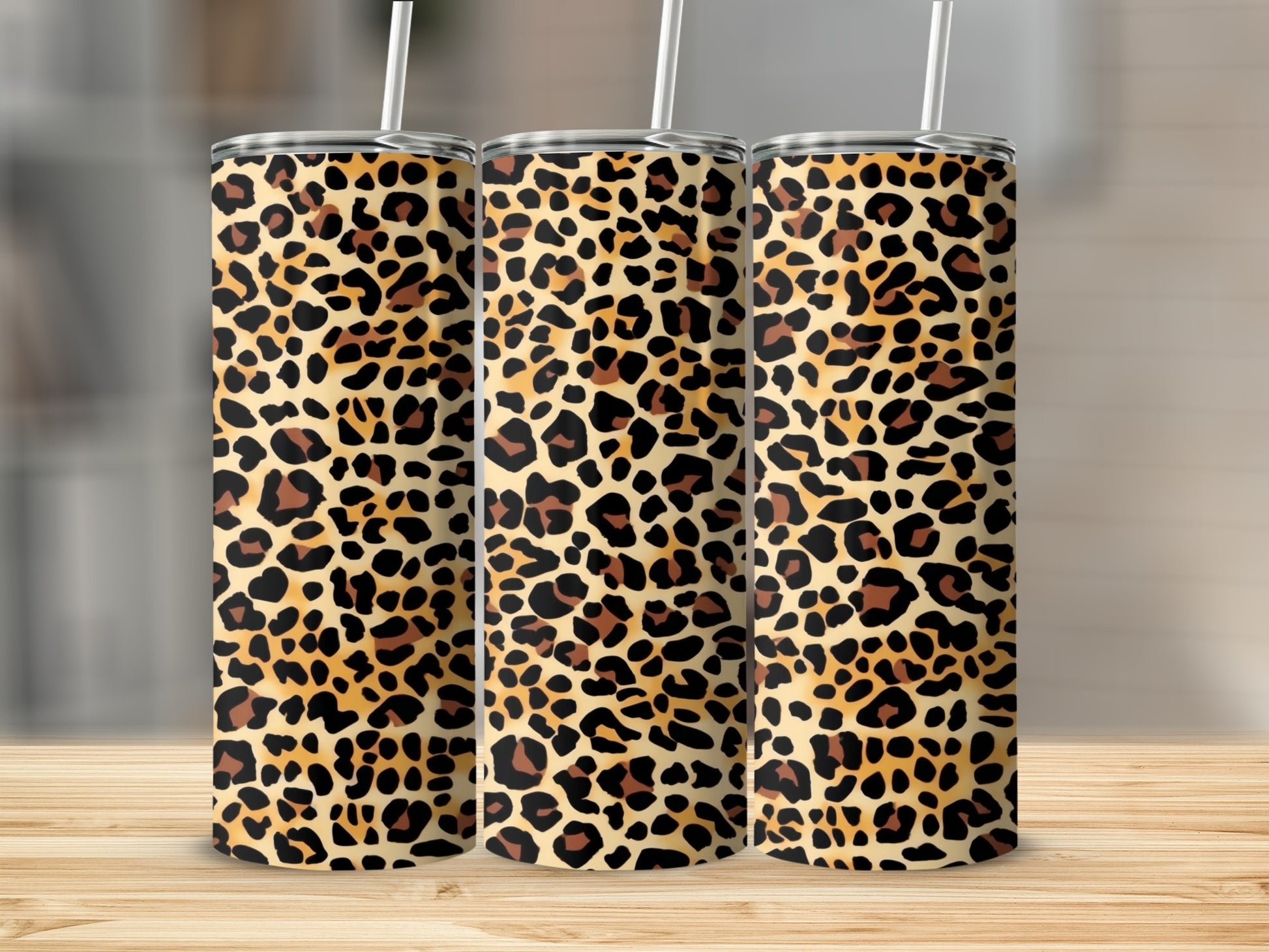 Three tumblers with leopard print patterns stand on a wooden surface.