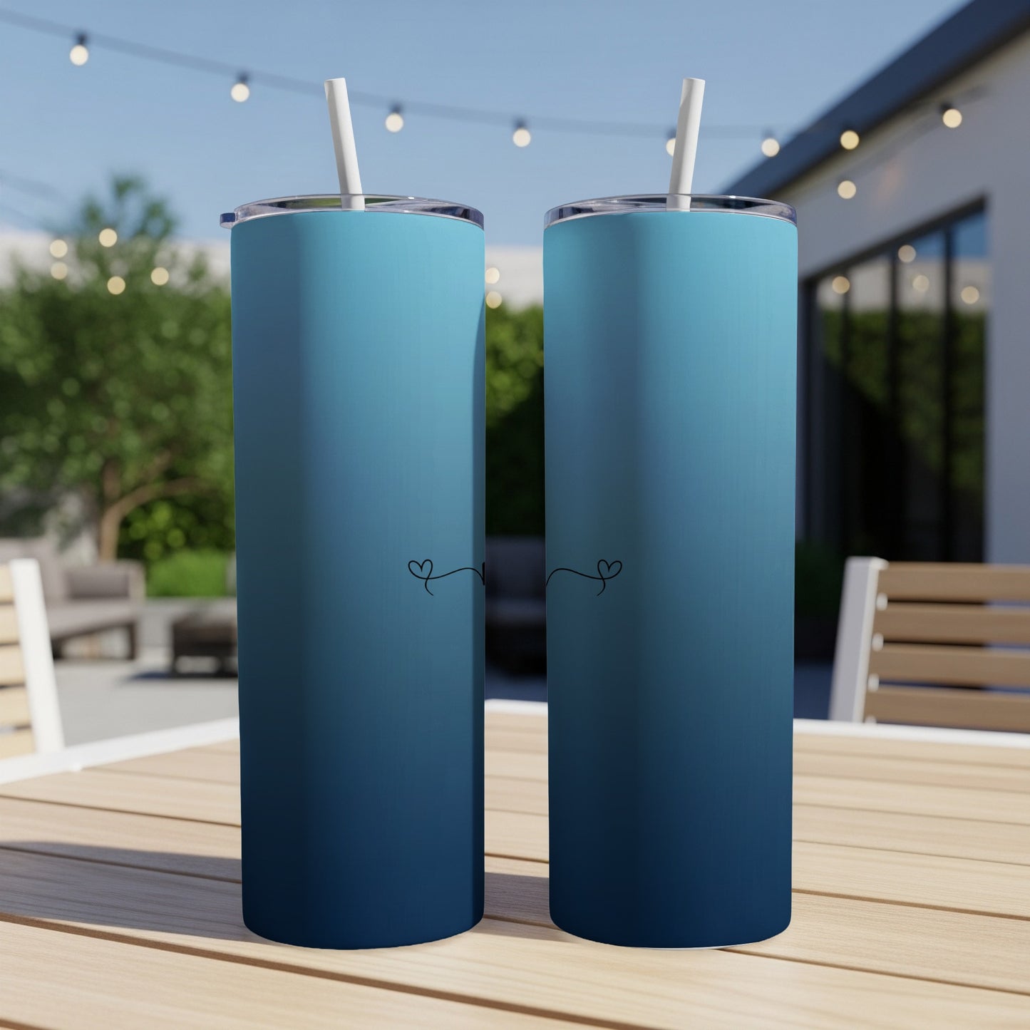 Two blue gradient tumblers with heart and vine designs.