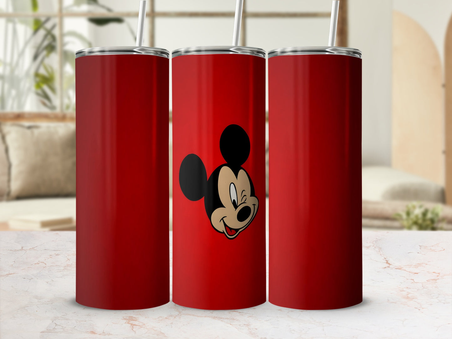 Red tumbler with Mickey Mouse graphic, plain tumblers on sides.