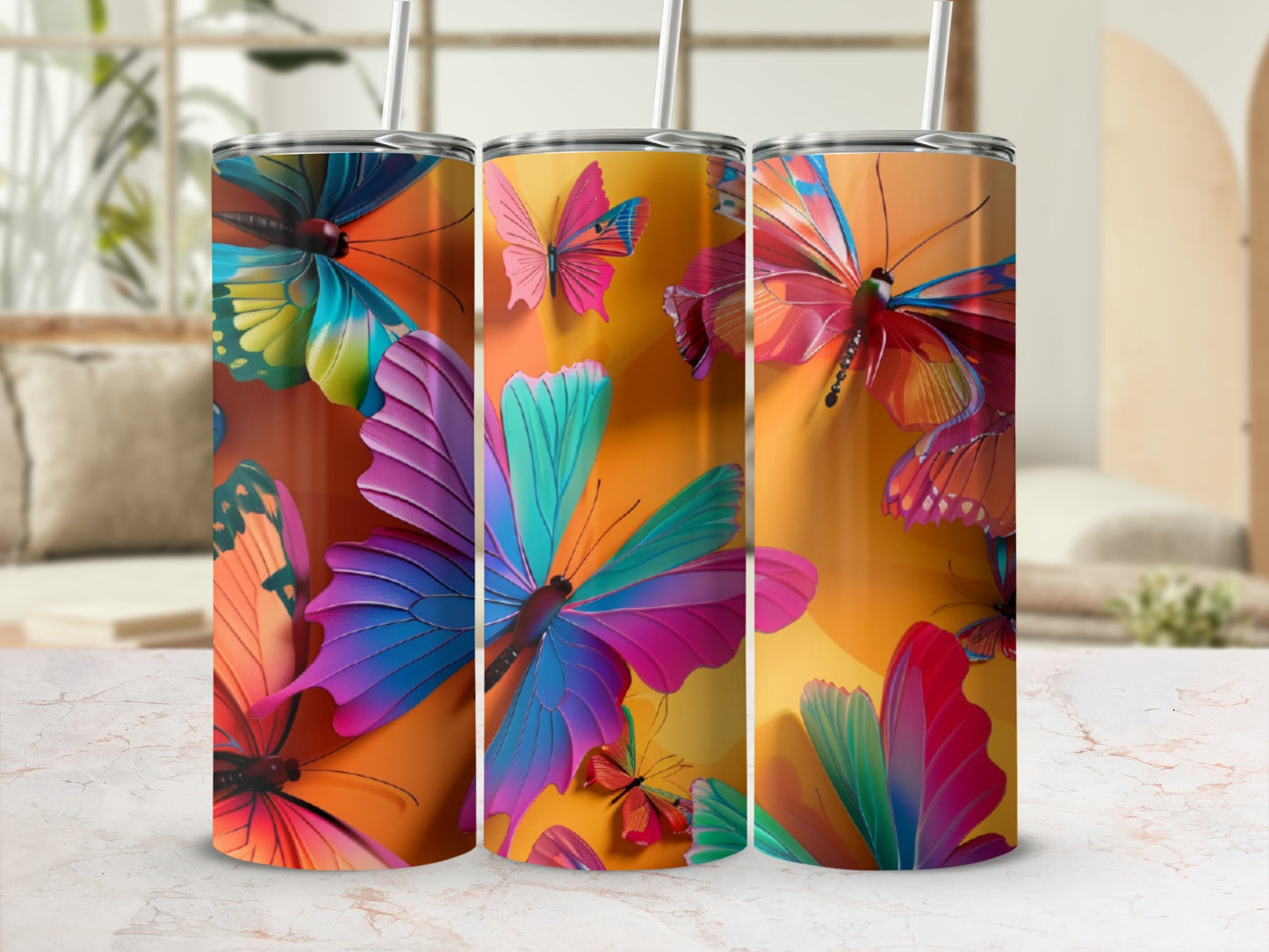 Three tall, skinny tumblers featuring vibrant, colorful butterflies on an orange background.