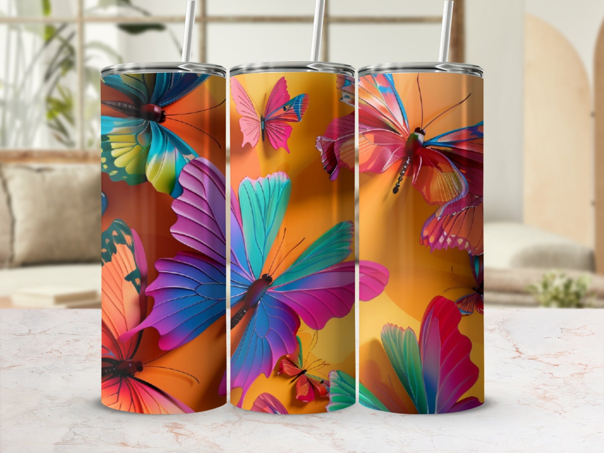 Three tall, skinny tumblers featuring vibrant, colorful butterflies on an orange background.