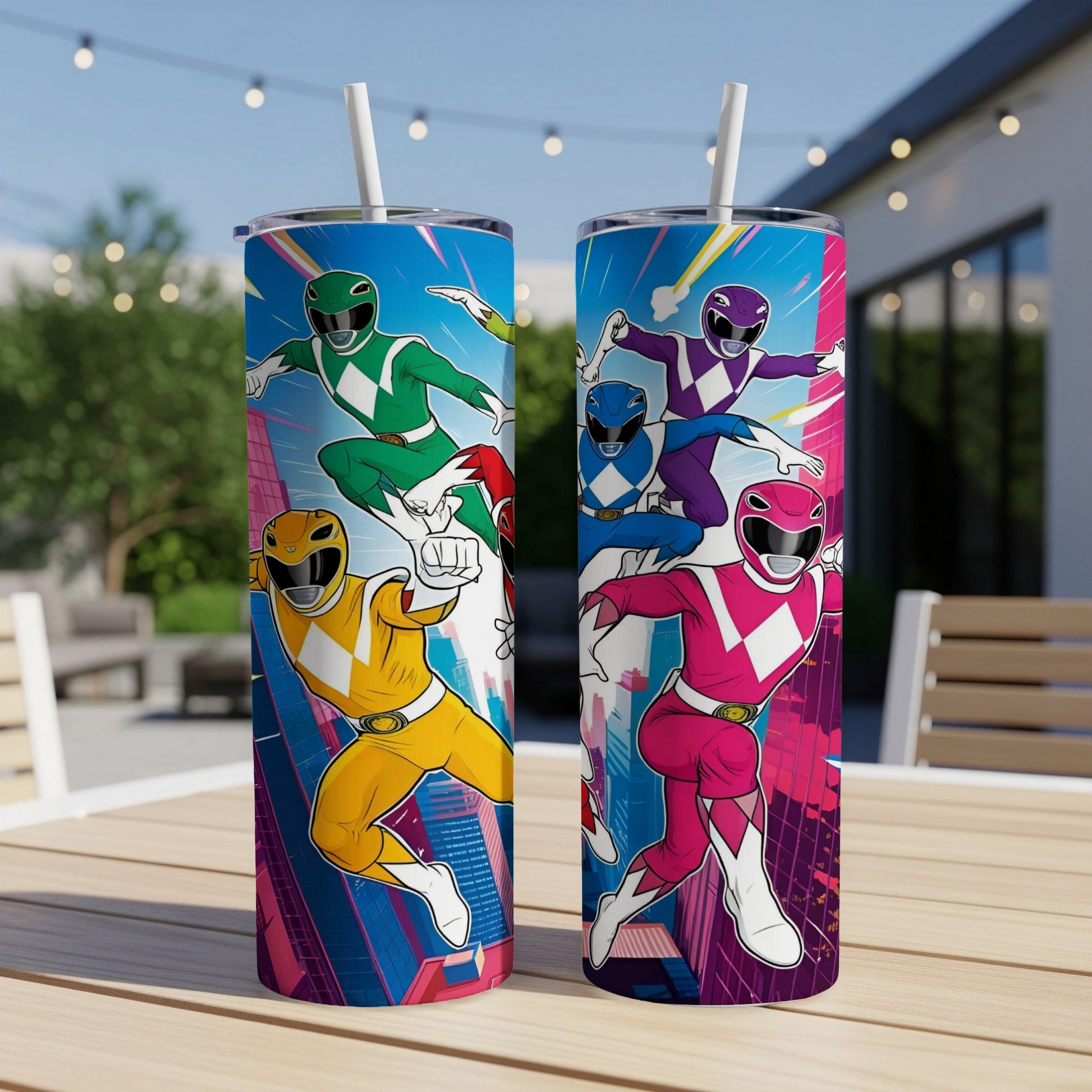 Two Power Rangers tumblers with colorful superhero designs on an outdoor table.