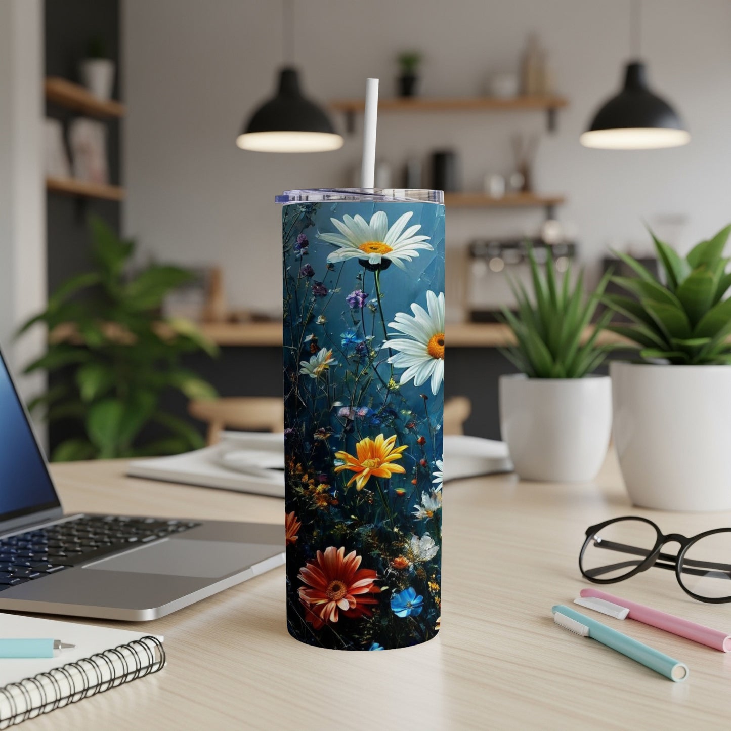 White tumbler with colorful floral design on desk.
