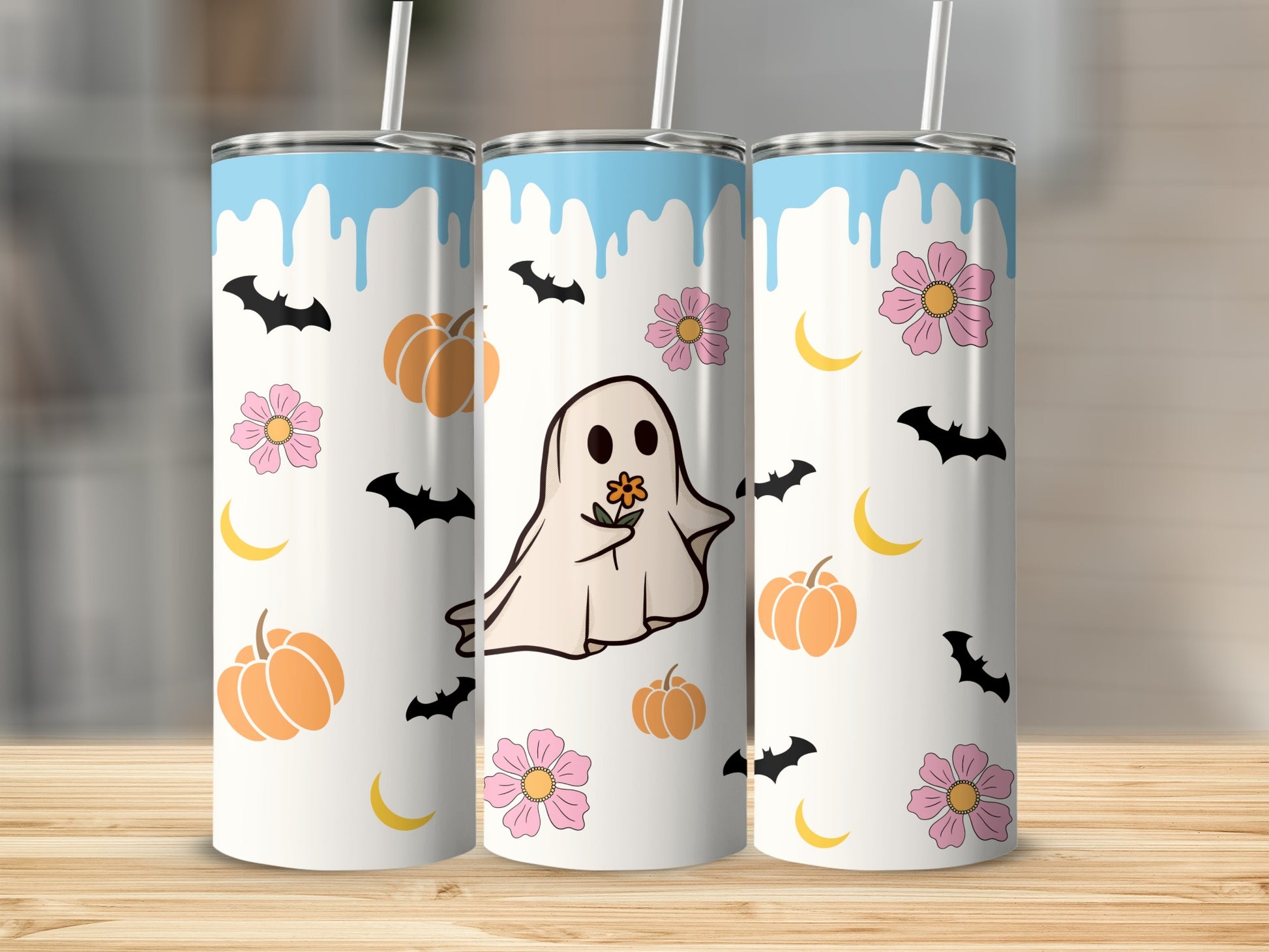 Three tumblers with a ghost, pumpkins, bats, moons, and flowers Halloween design.