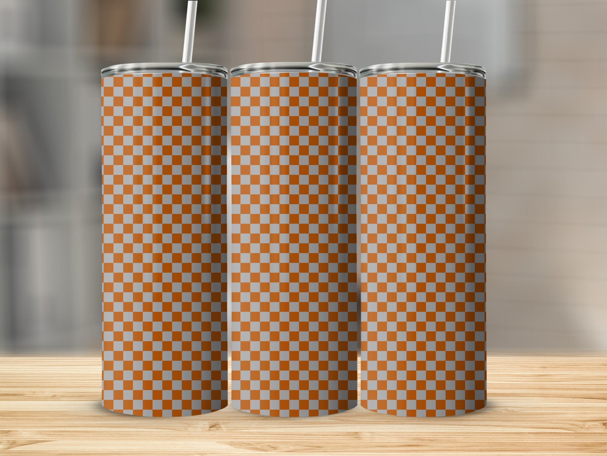 Three tall, patterned tumblers with a checkered orange and grey design.