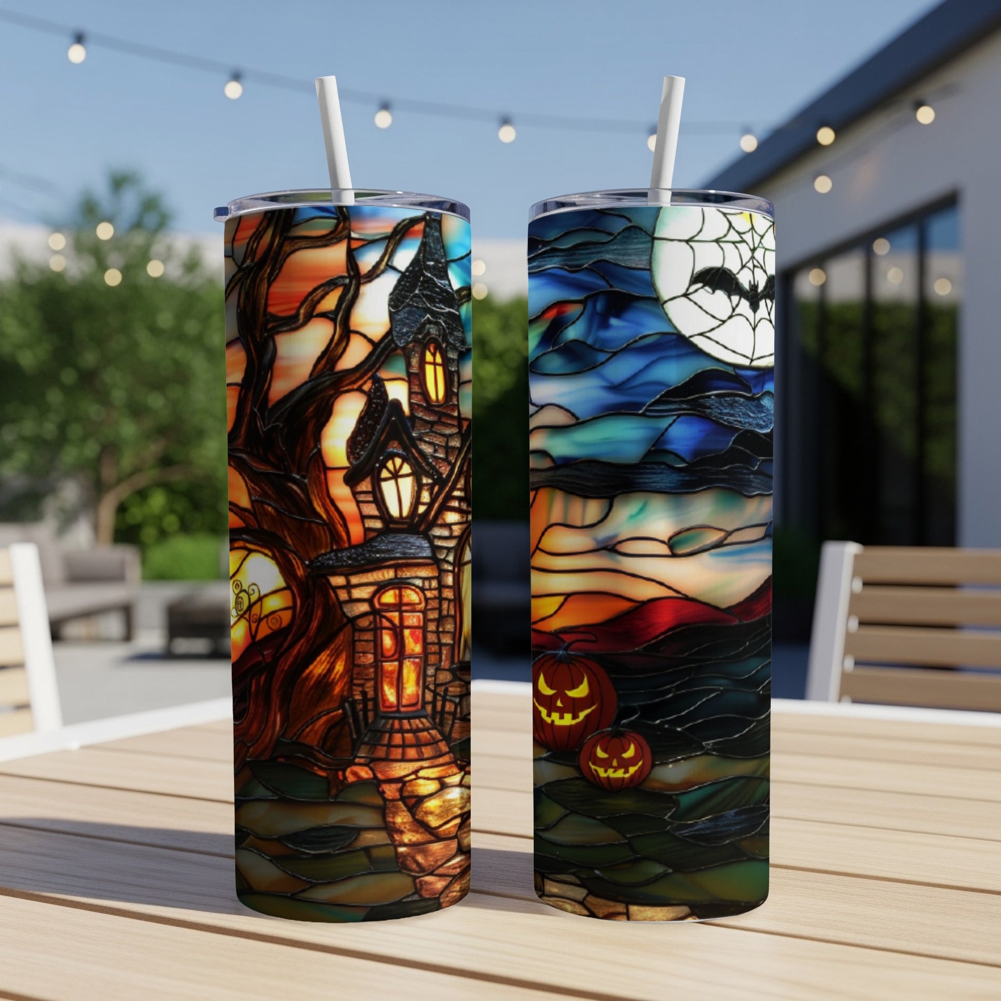 Two Halloween-themed tumblers, one with a haunted house, the other with pumpkins and a moon.